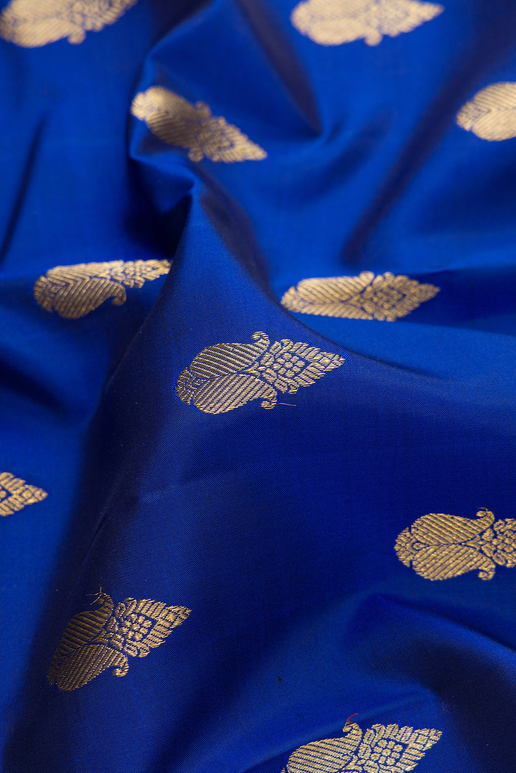 Close up of Pure Silk Pure Zari Royal Blue Kanjivaram Saree with Zari Butta on the body and Zari Border.  displaying folds
