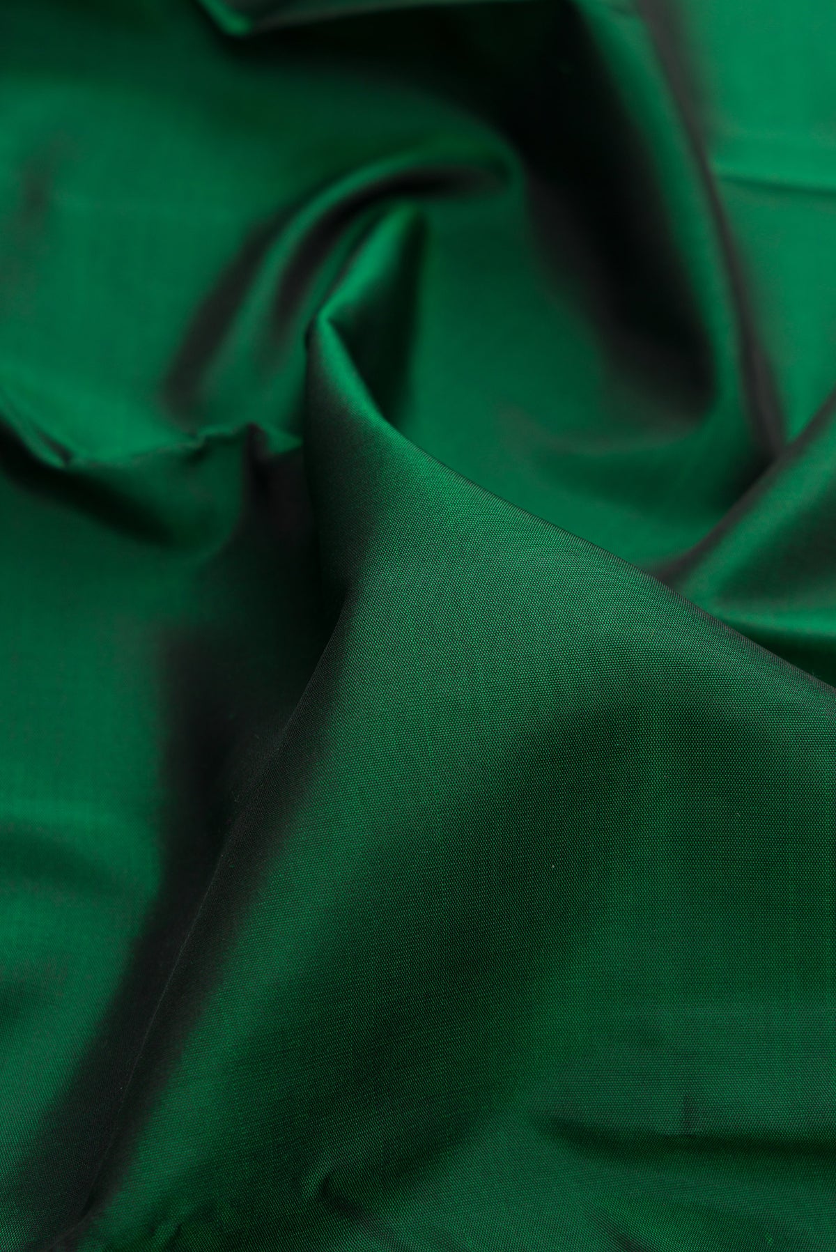 Close up of Pure Silk Pure Zari Bottle Green Kanjivaram Saree with Plain Body and Fancy Border.  displaying folds