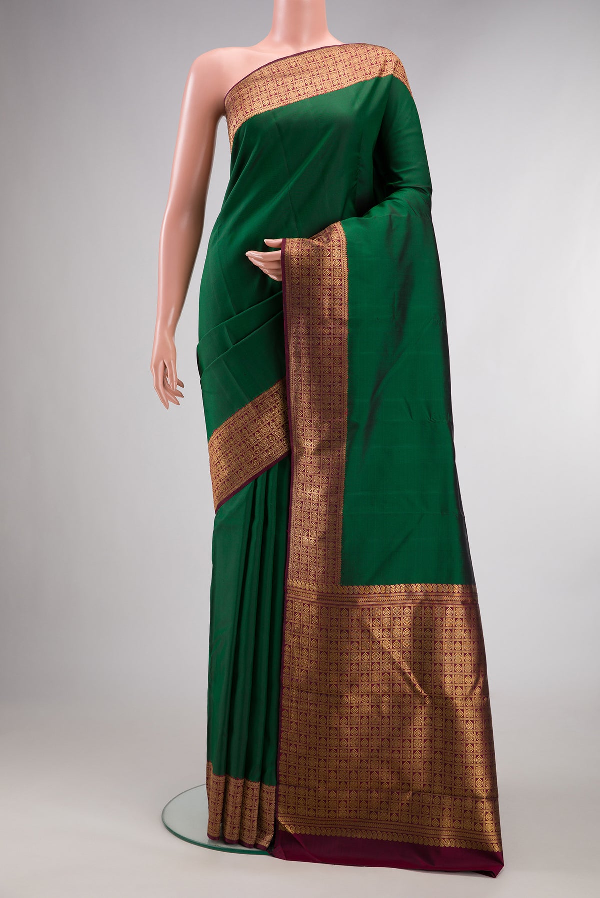 Pure Silk Pure Zari Bottle Green Kanjivaram Saree with Plain Body and Fancy Border.  displayed on a mannequin