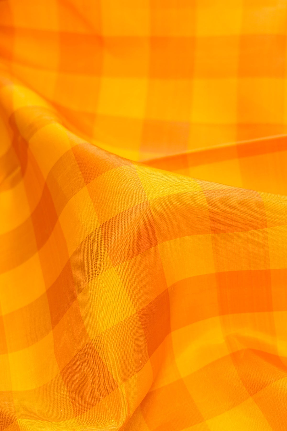 Close up of Pure Silk Pure Zari Yellow Kanjivaram Saree with Checked design on the body and Zari Border.  displaying folds