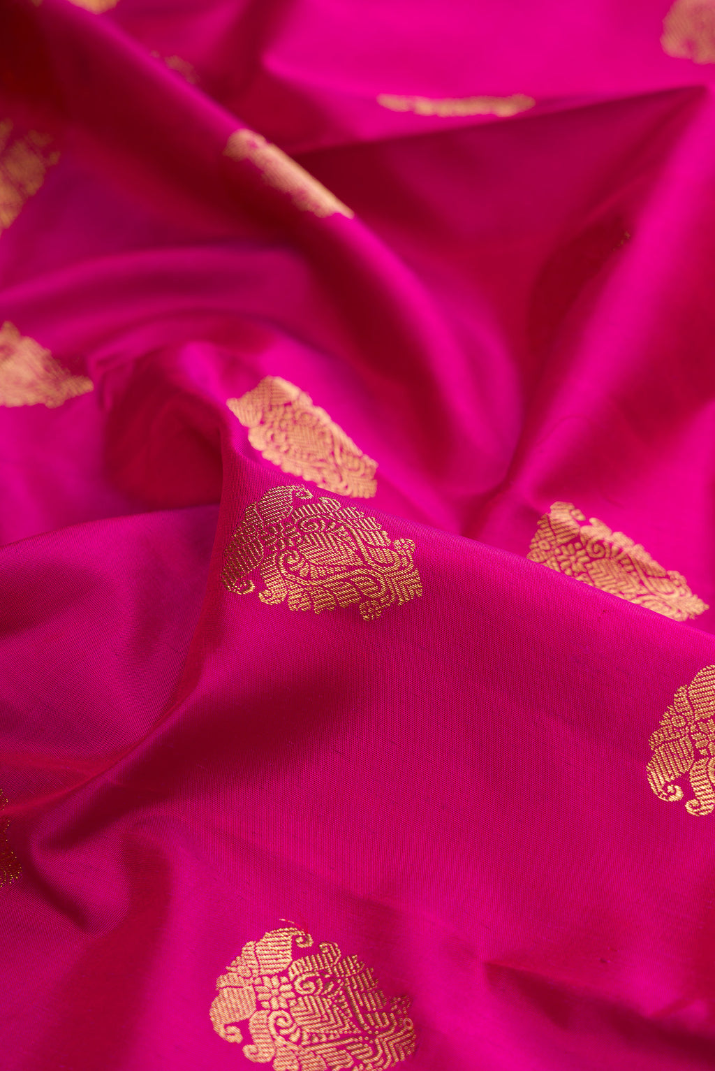 Close up of Pure Silk Pure Zari Light Magenta Kanjivaram Saree with Zari Butta on the body and Zari Border.  displaying folds