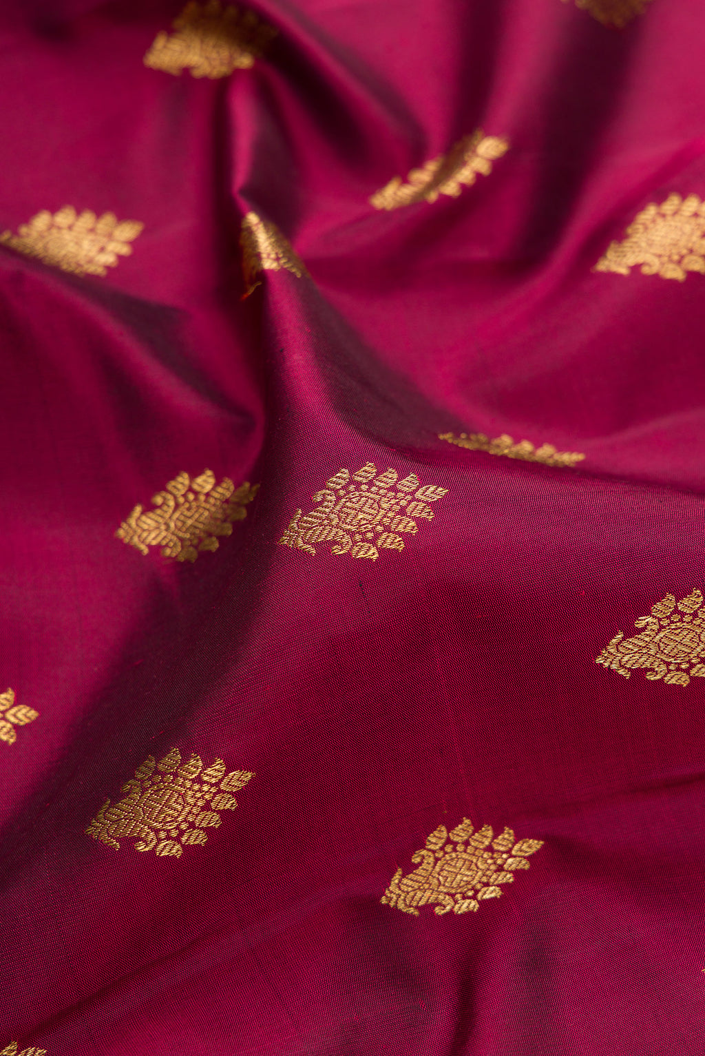 Close up of Pure Silk Pure Zari Maroon Kanjivaram Saree with Zari Butta on the body and Fancy Border.  displaying folds