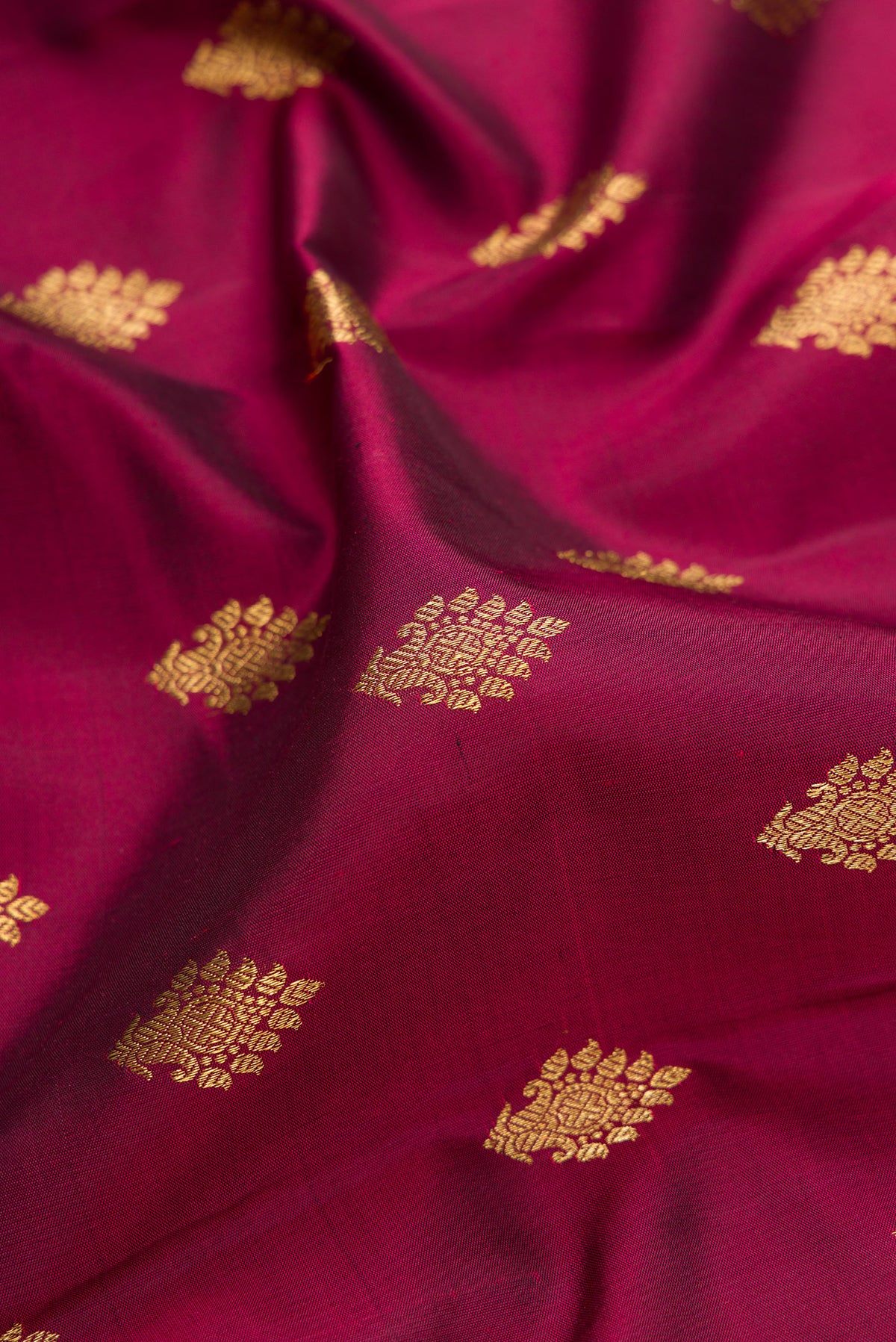 Close up of Pure Silk Pure Zari Maroon Kanjivaram Saree with Zari Butta on the body and Fancy Border.  displaying folds