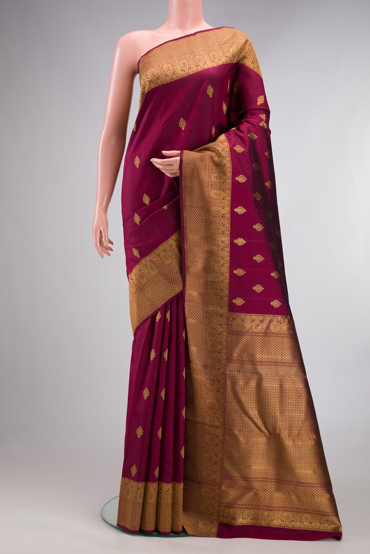 Pure Silk Pure Zari Maroon Kanjivaram Saree with Zari Butta on the body and Fancy Border.  displayed on a mannequin