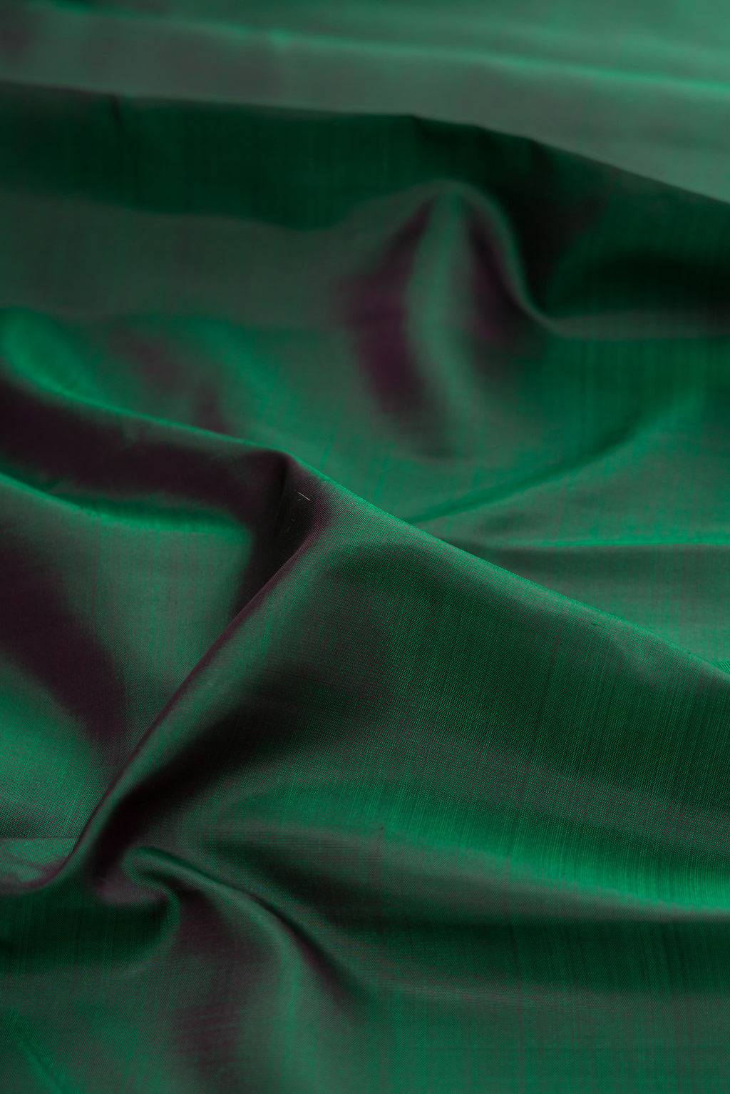 Close up of Pure Silk Pure Zari Green Kanjivaram Saree with Plain Body and Zari Border.  displaying folds
