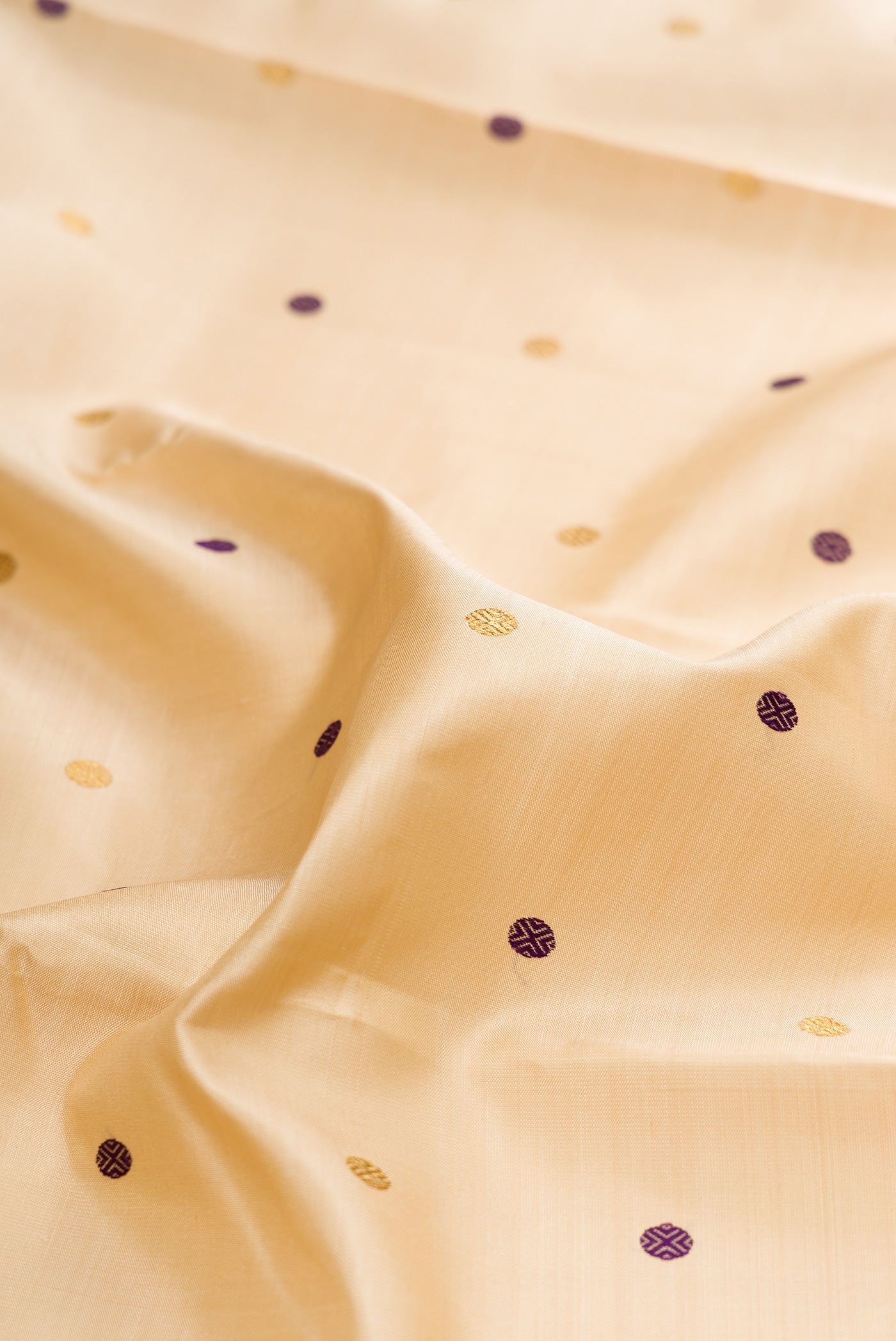 Close up of Pure Silk Pure Zari Sandal Kanchipuram Saree with Zari And Thread Butta on the body and Zari Border.  displaying folds