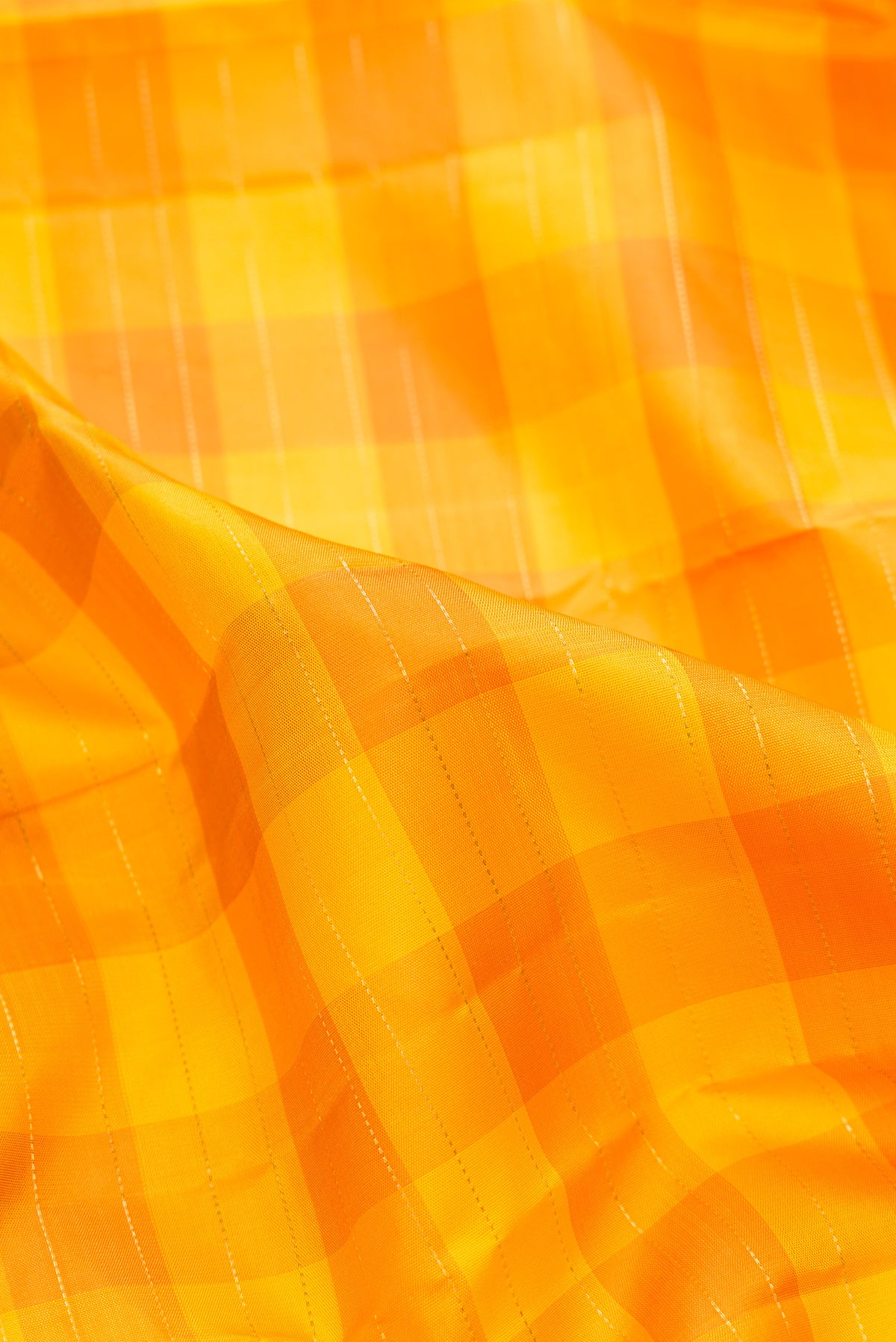 Close up of Pure Silk Pure Zari Yellow Kanjivaram Saree with Checked design on the body and Zari Border.  displaying folds