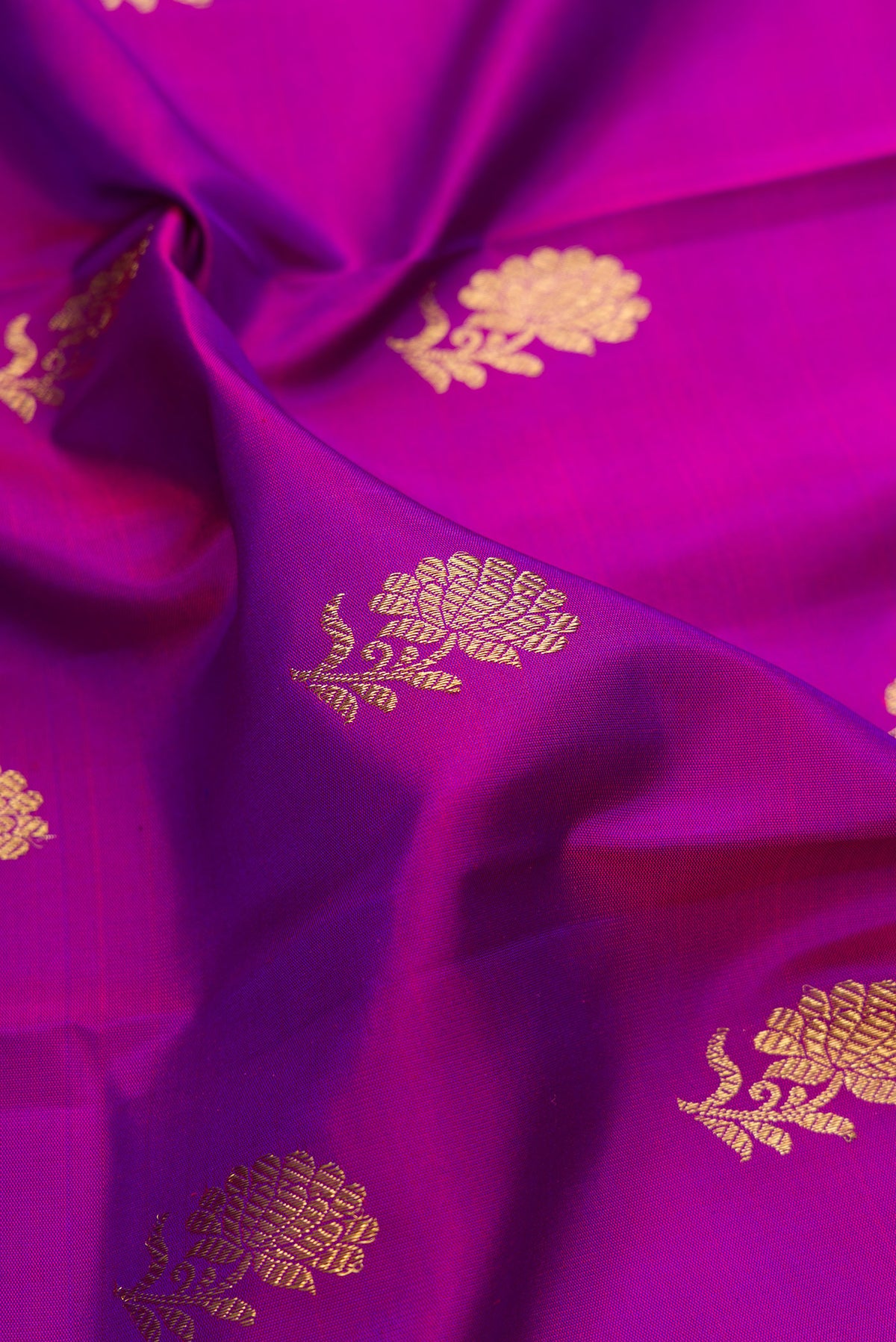 Close up of Pure Silk Pure Zari Purple Kanjivaram Saree with Zari Butta on the body and Fancy Border.  displaying folds