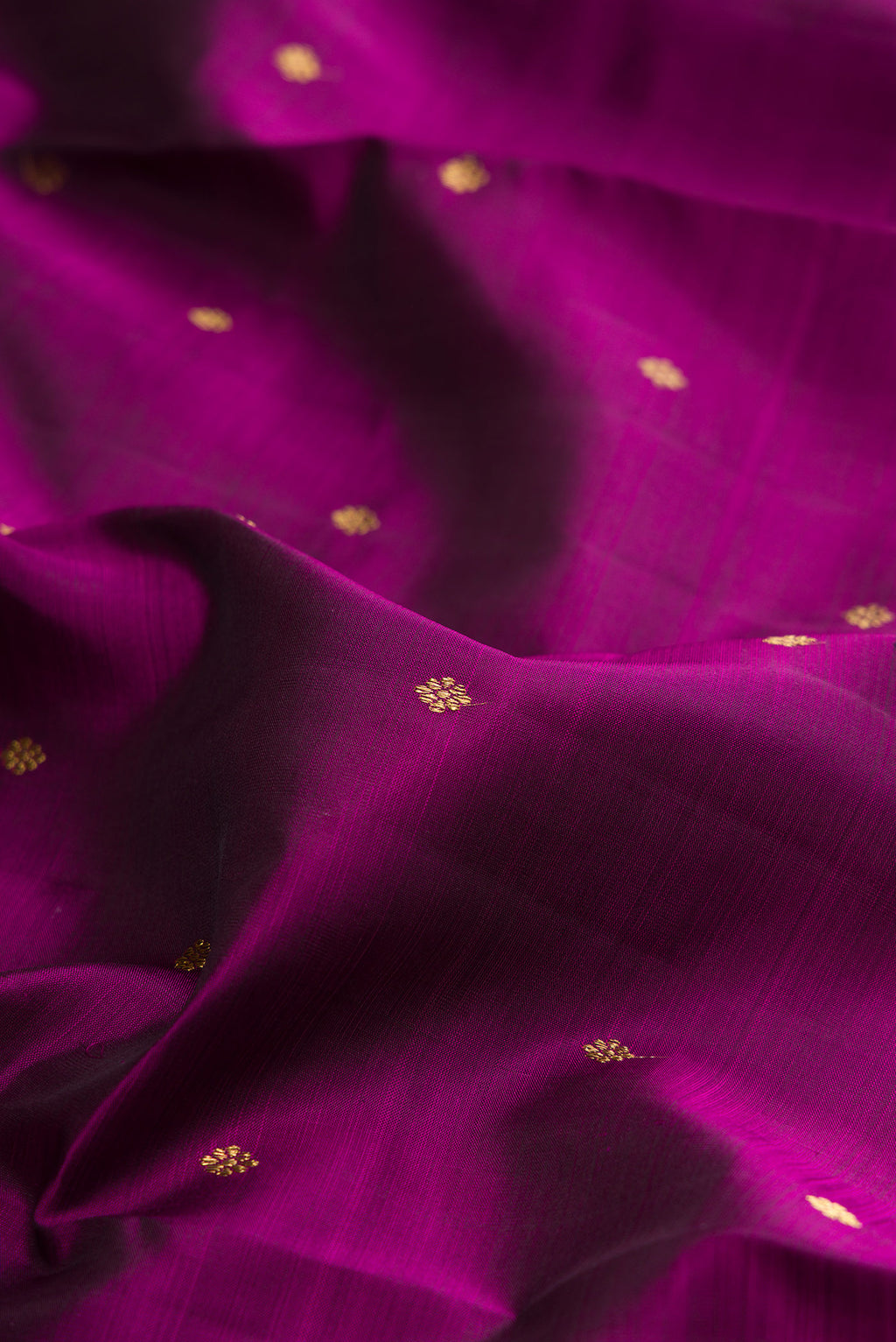 Close up of Pure Silk Pure Zari Magenta Kanjivaram Saree with Zari Butta on the body and Zari Border.  displaying folds