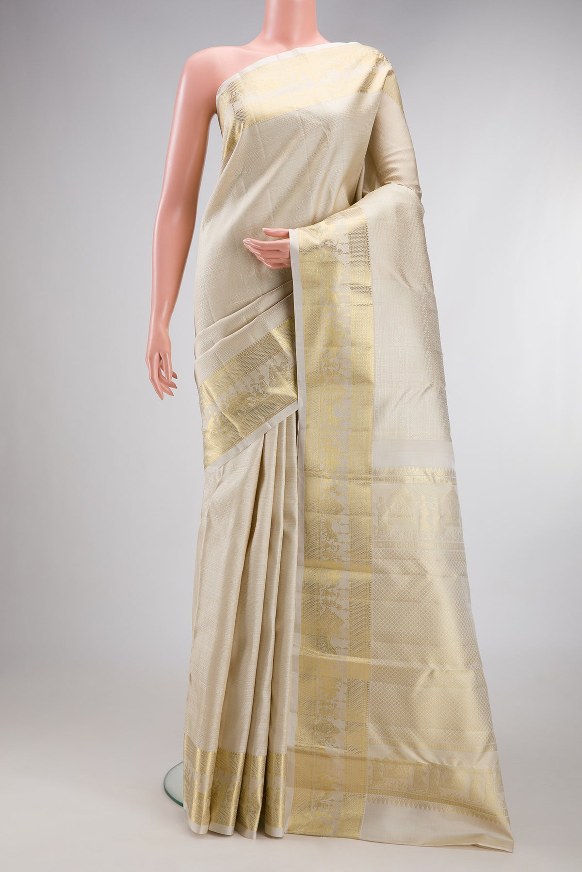 Cream Kanjivaram Silk Saree with Jacquard design on the body and Zari Border.  displayed on a mannequin