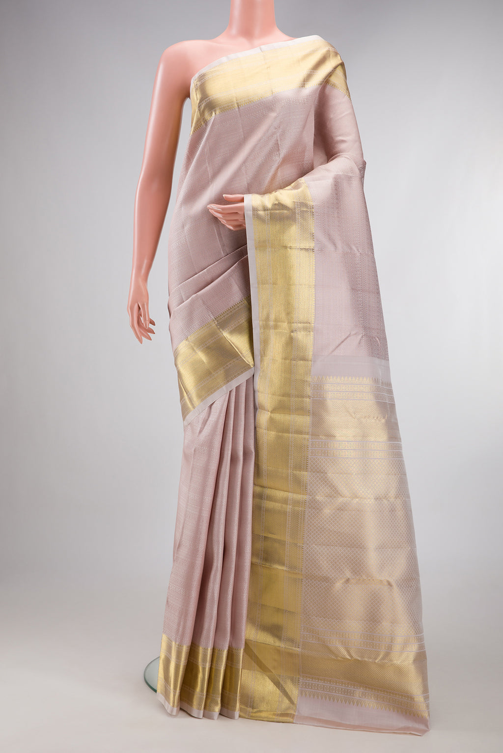 Rose Gold Kanjivaram Silk Saree with Jacquard design on the body and Zari Border.  displayed on a mannequin