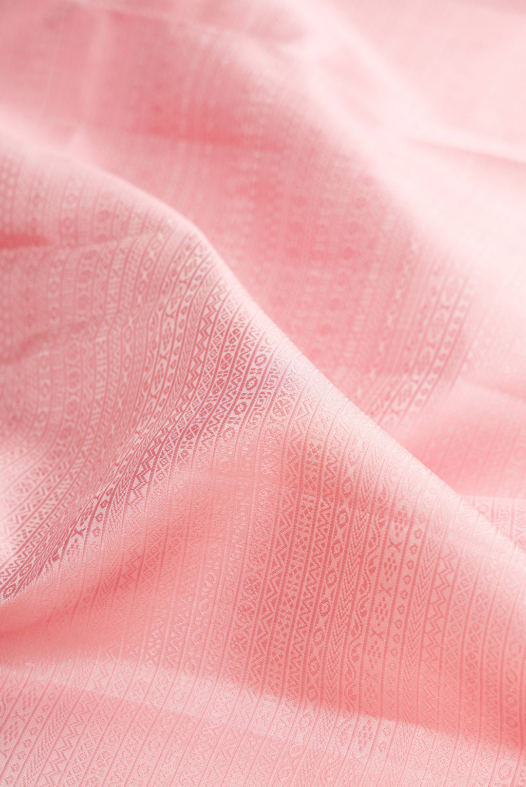 Close up of Rose pink Kanjivaram Silk Saree with Jacquard design on the body and Zari Border.  displaying folds
