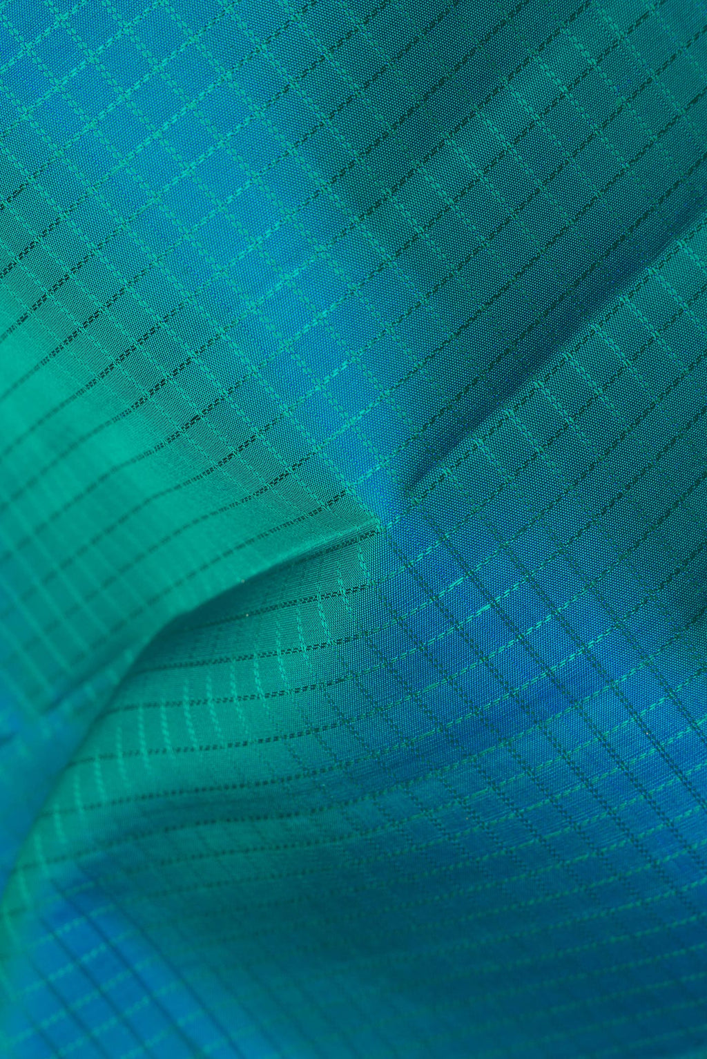 Close up of Pure Silk Peacock Blue Dual Tone Kanchipuram Saree with Checked design on the body and Zari Border.  displaying folds