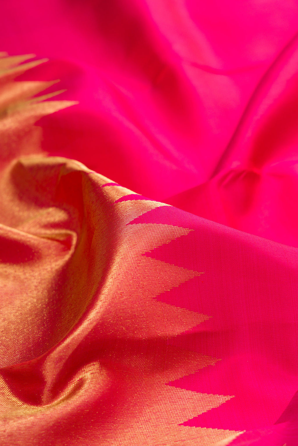 Close up of Pure Silk Pink Kanjivaram Saree with Plain Body and Rising Temple Border.  displaying folds