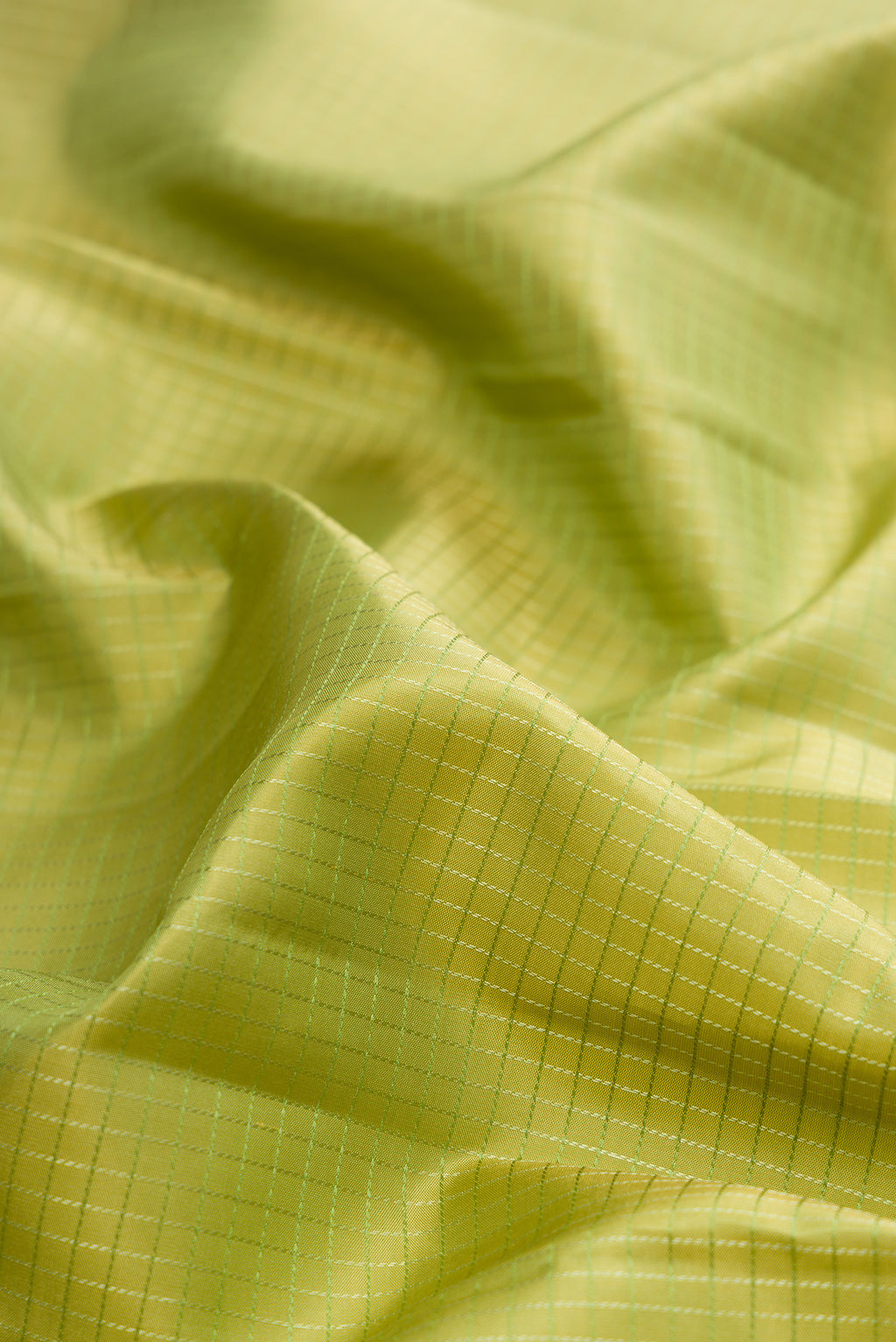 Close up of Pure Silk Pista Green Kanchipuram Saree with Checked design on the body and Zari Border.  displaying folds