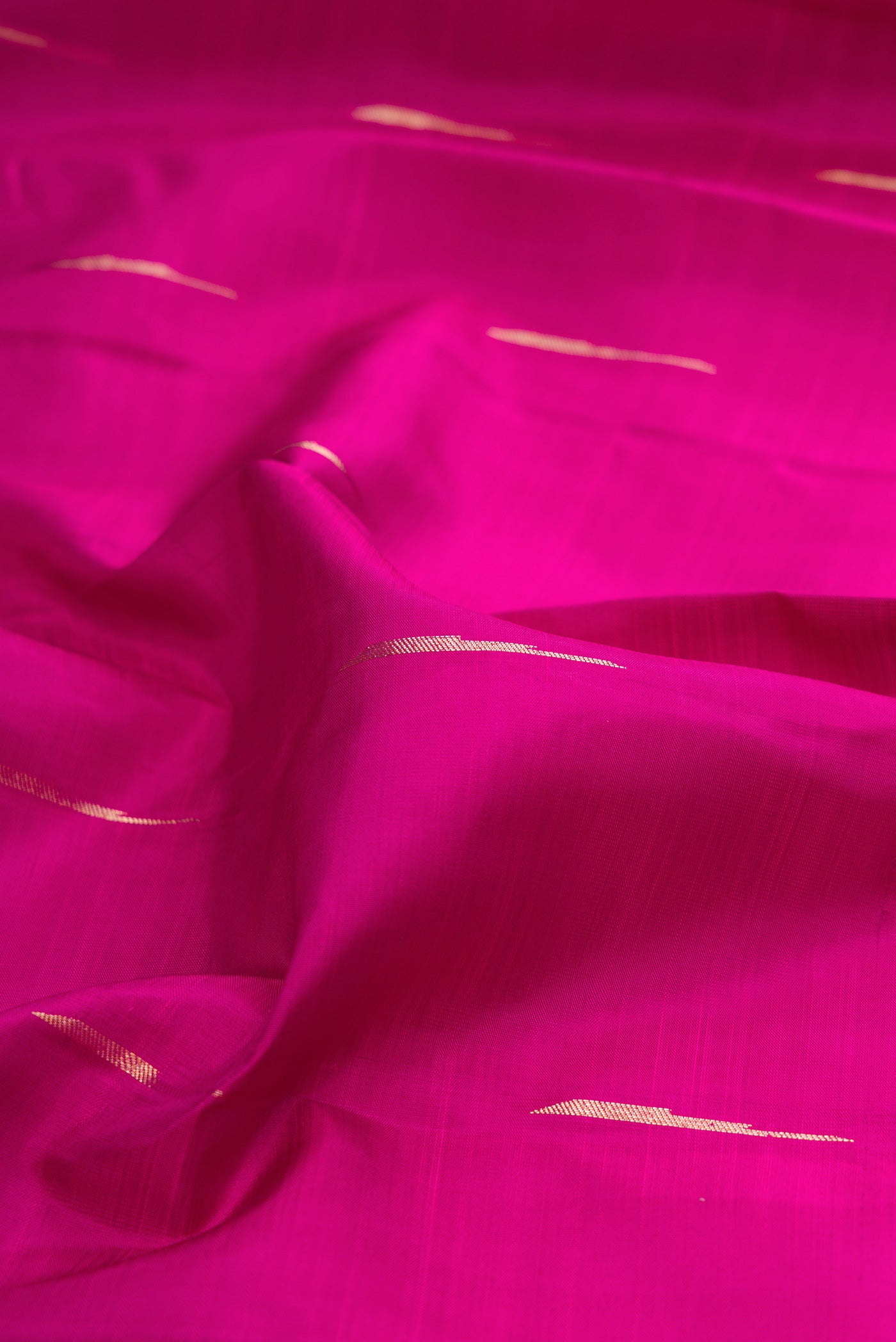 Close up of Pure Silk Magenta Kanjivaram Saree with Zari Butta on the body and Fancy Border.  displaying folds