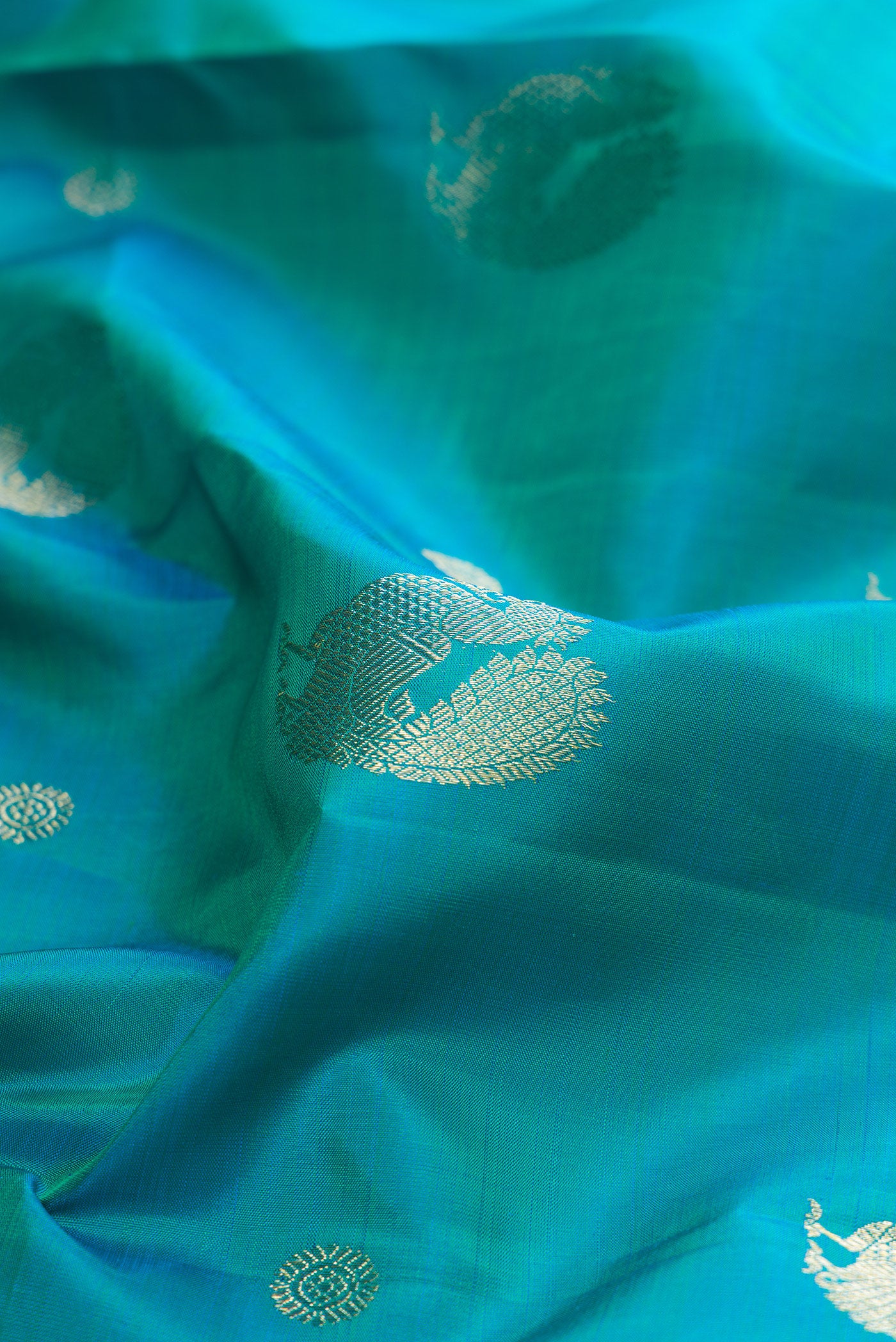 Close up of Pure Silk Blue Kanjivaram Saree with Zari Butta on the body and Zari Border.  displaying folds