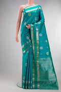 Pure Silk Blue Kanjivaram Saree with Zari Butta on the body and Zari Border.  displayed on a mannequin