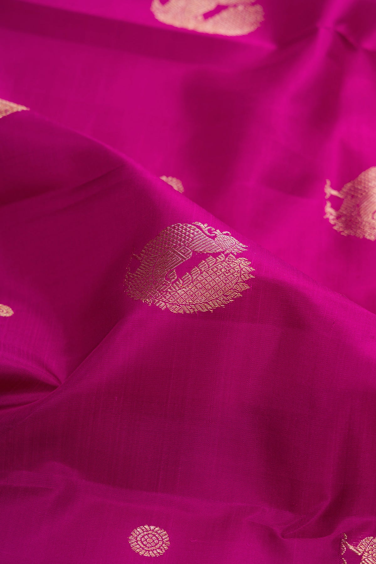 Close up of Pure Silk Magenta Kanjivaram Saree with Zari Butta on the body and Zari Border.  displaying folds