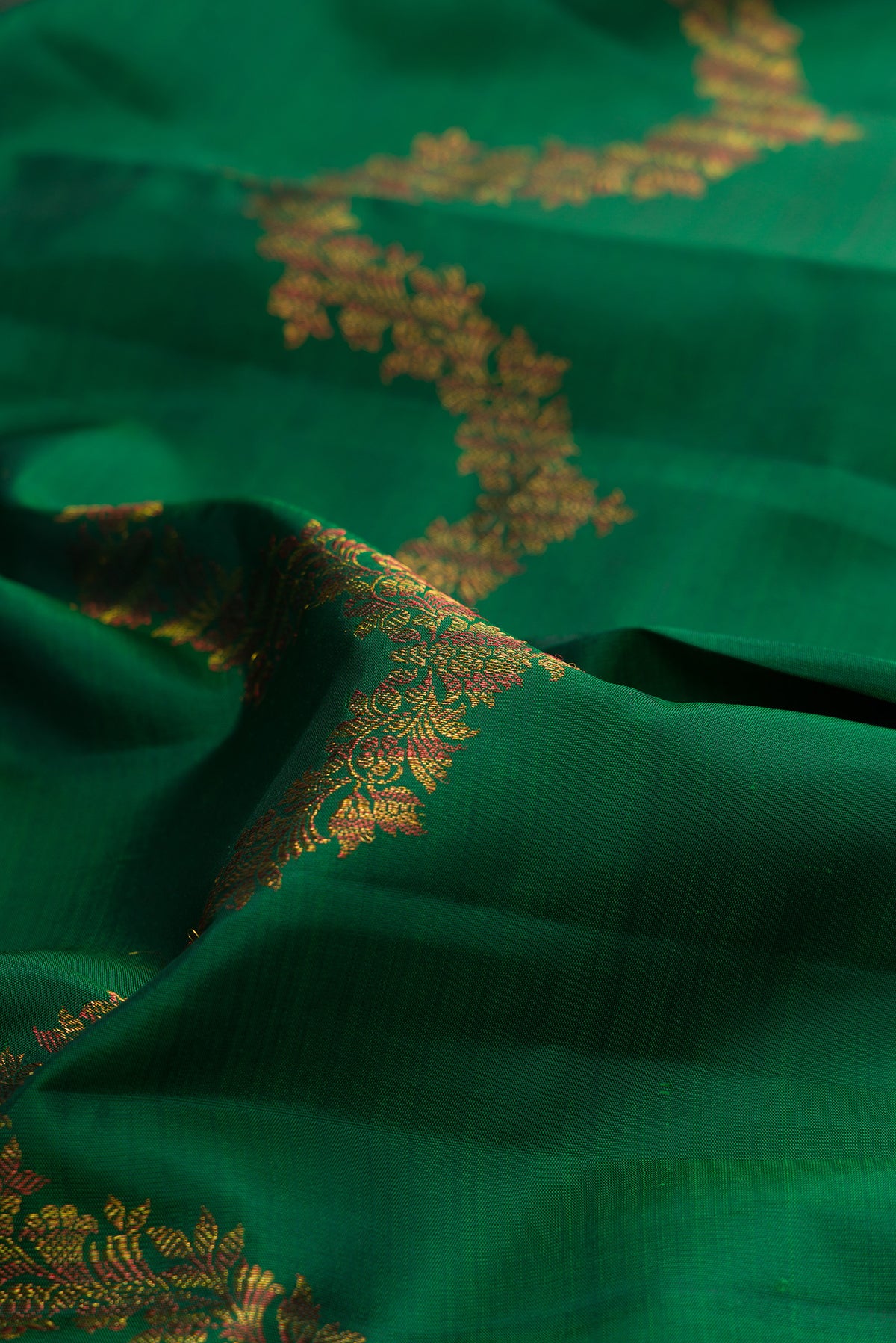 Close up of Pure Silk Bottle Green Kanjivaram Saree with Zig Zag design on the body and Without Border.  displaying folds