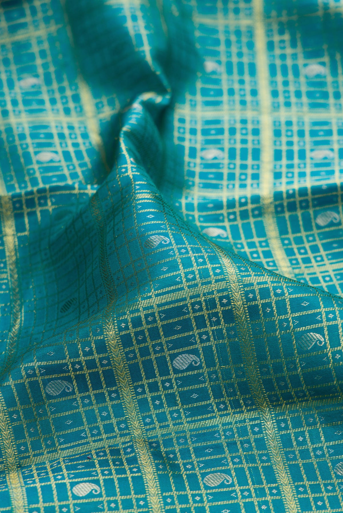 Close up of Pure Silk Peacock Blue Kanchipuram Saree with Checked design on the body and Zari Border.  displaying folds