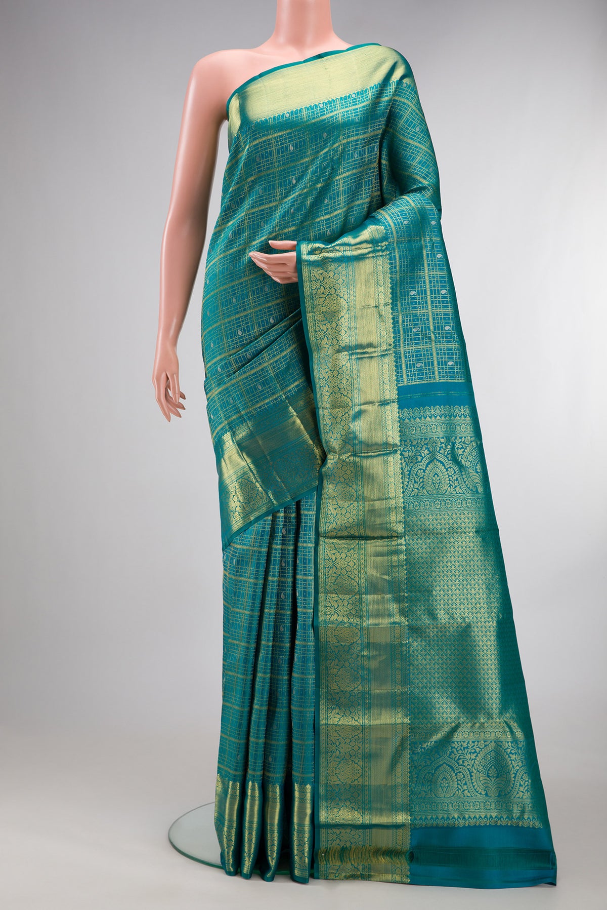 Pure Silk Peacock Blue Kanchipuram Saree with Checked design on the body and Zari Border.  displayed on a mannequin