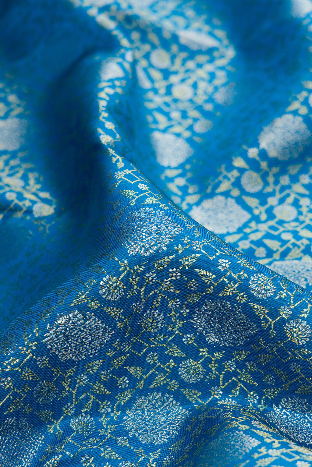 Close up of Pure Silk Peacock Blue Kanchipuram Saree with Zari Brocade on the body and Zari Border.  displaying folds