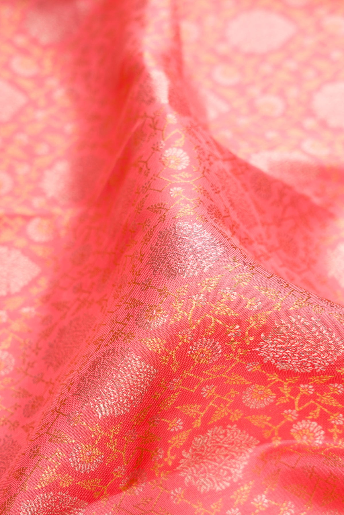 Close up of Pure Silk Coral Kanchipuram Saree with Zari Brocade on the body and Zari Border.  displaying folds