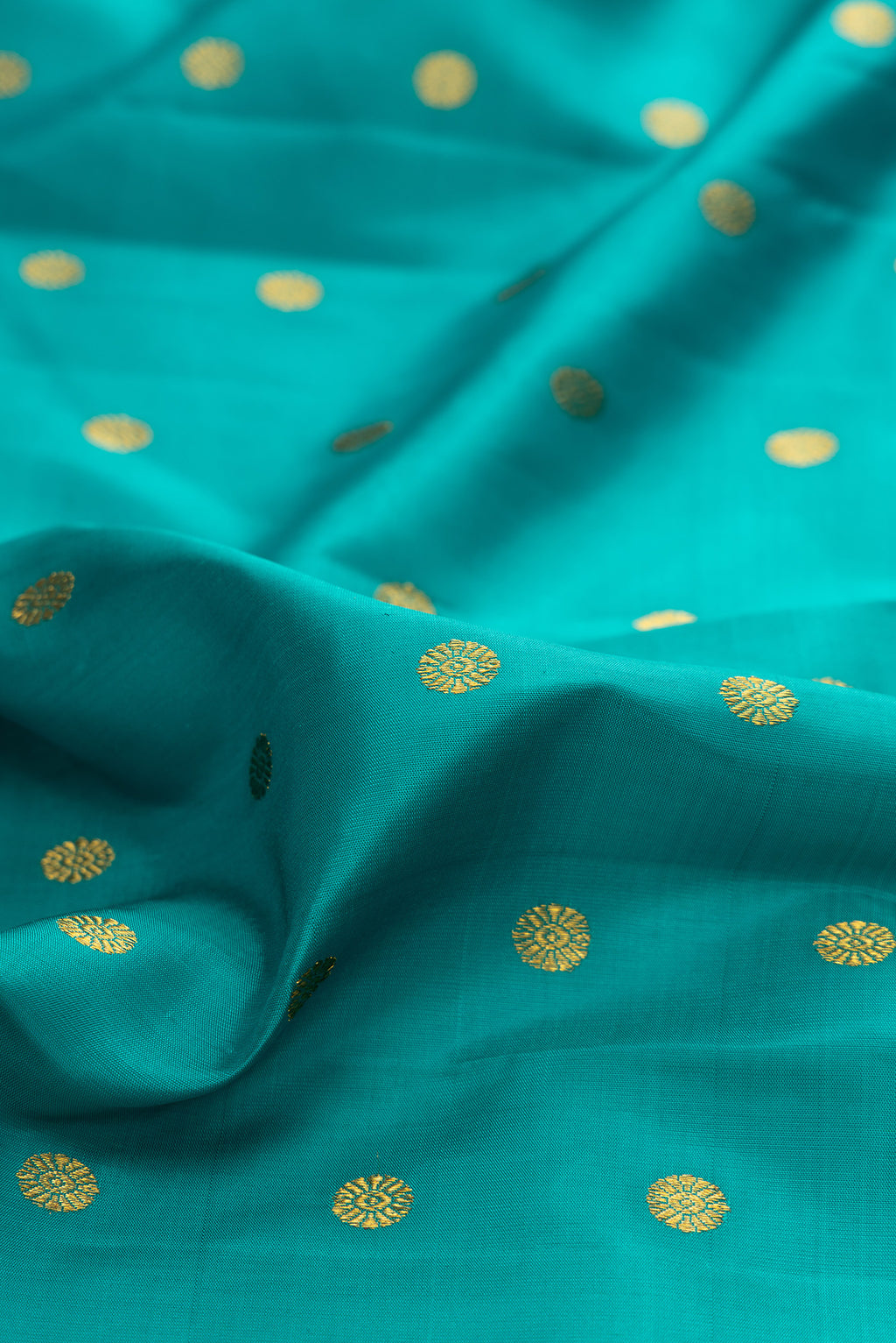 Close up of Pure Silk Green Dual Tone Kanjivaram Saree with Zari Butta on the body and Fancy Border.  displaying folds