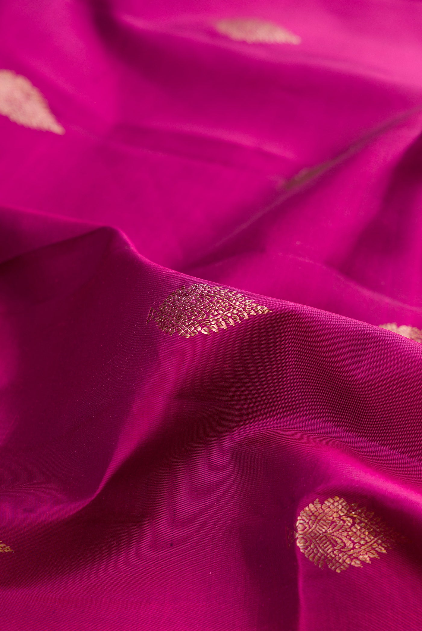 Close up of Pure Silk Magenta Kanjivaram Saree with Zari Butta on the body and Zari Border.  displaying folds