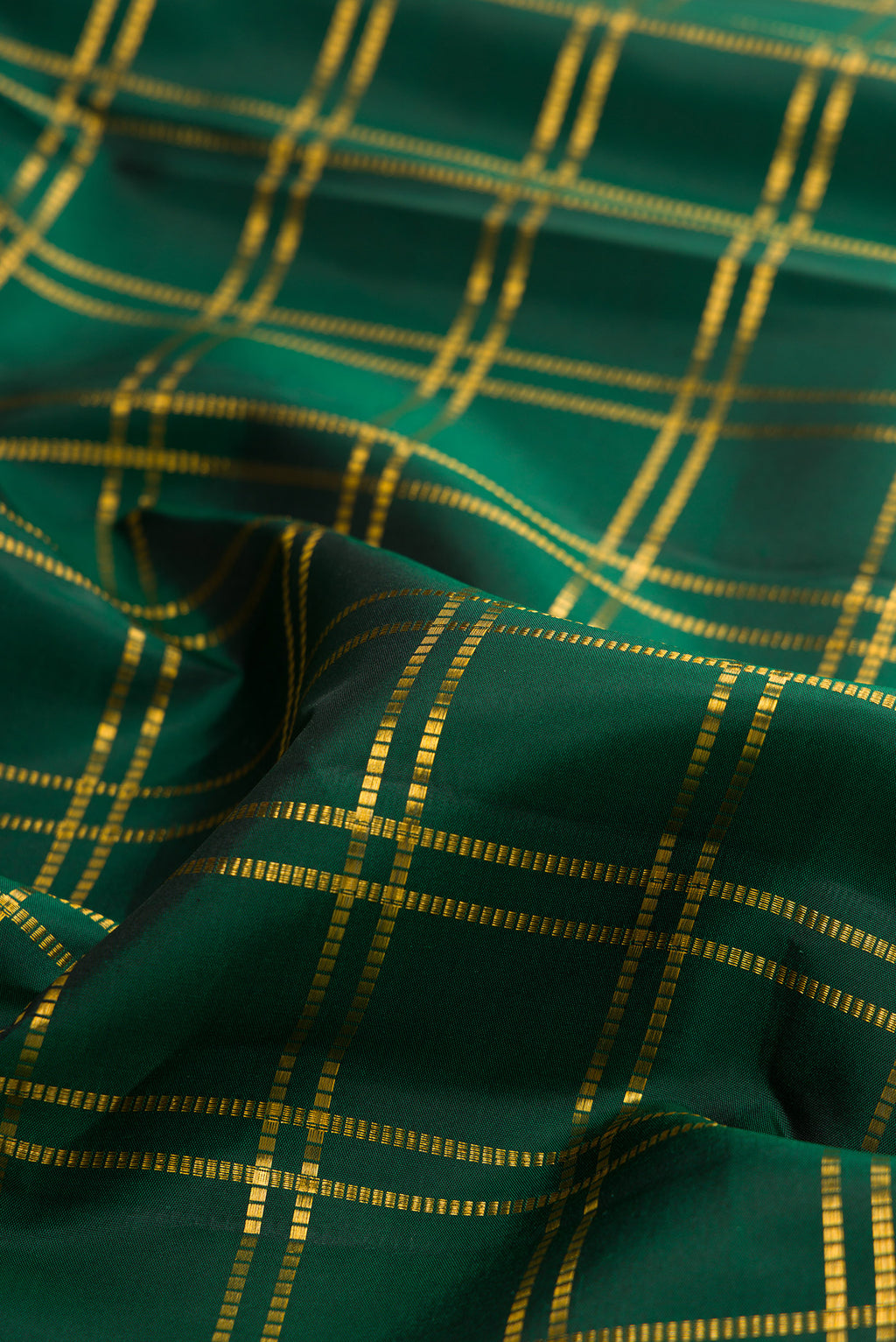 Close up of Pure Silk Bottle Green Kanjivaram Saree with Checked design on the body and Zari Border.  displaying folds