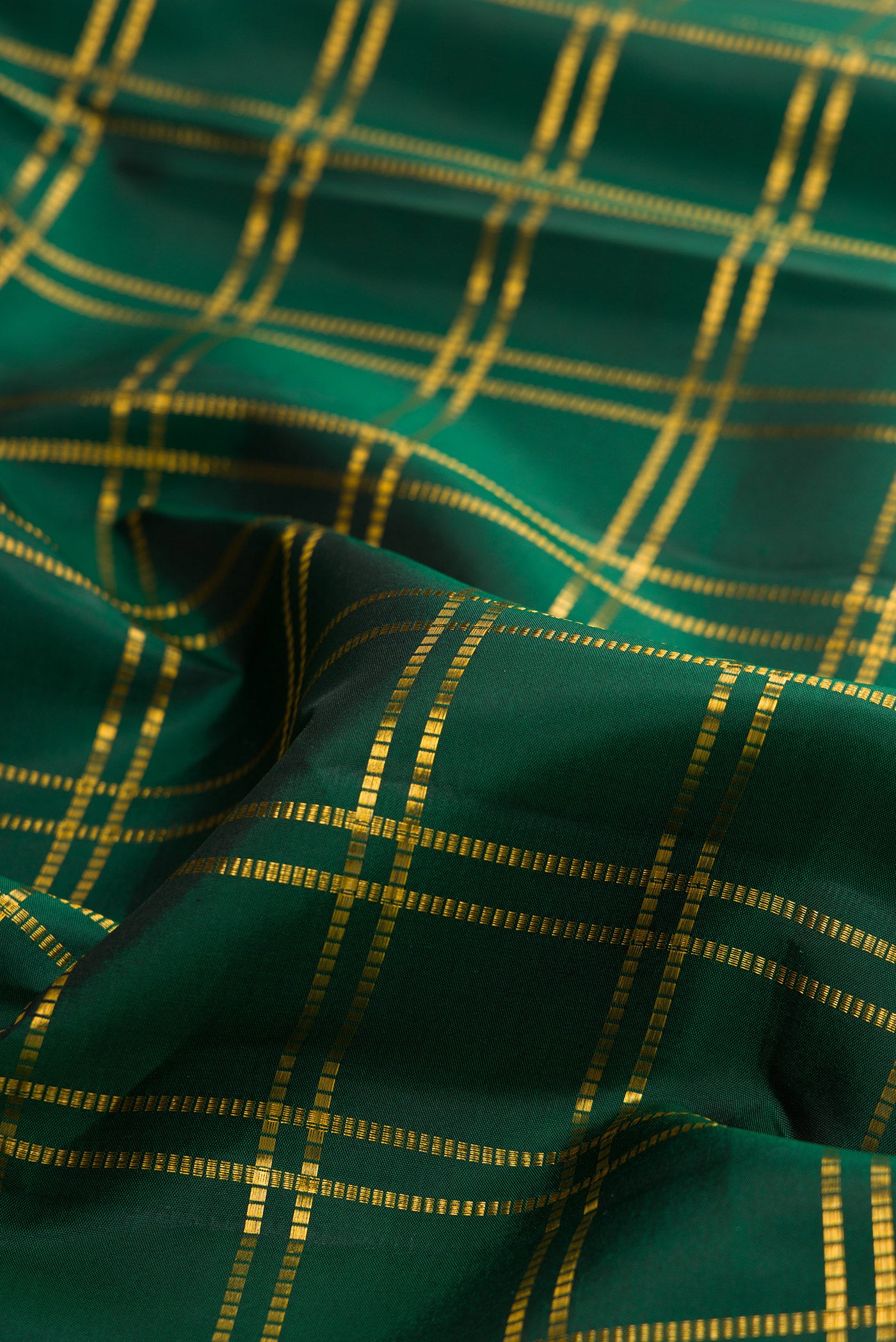Close up of Pure Silk Bottle Green Kanjivaram Saree with Checked design on the body and Zari Border.  displaying folds