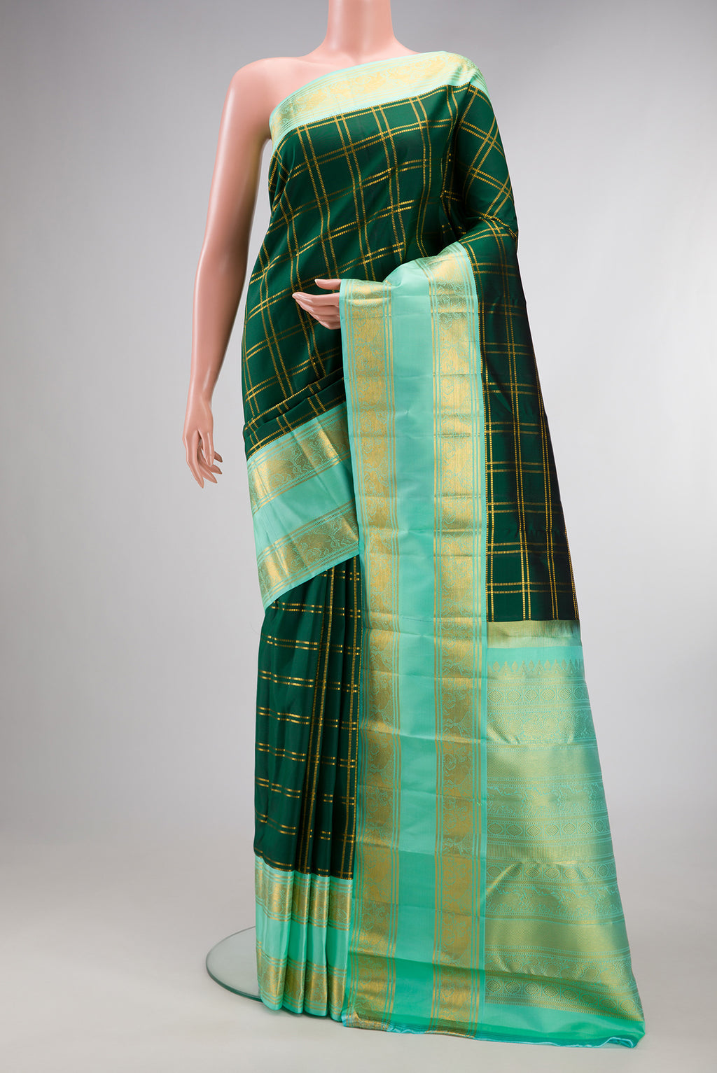 Pure Silk Bottle Green Kanjivaram Saree with Checked design on the body and Zari Border.  displayed on a mannequin