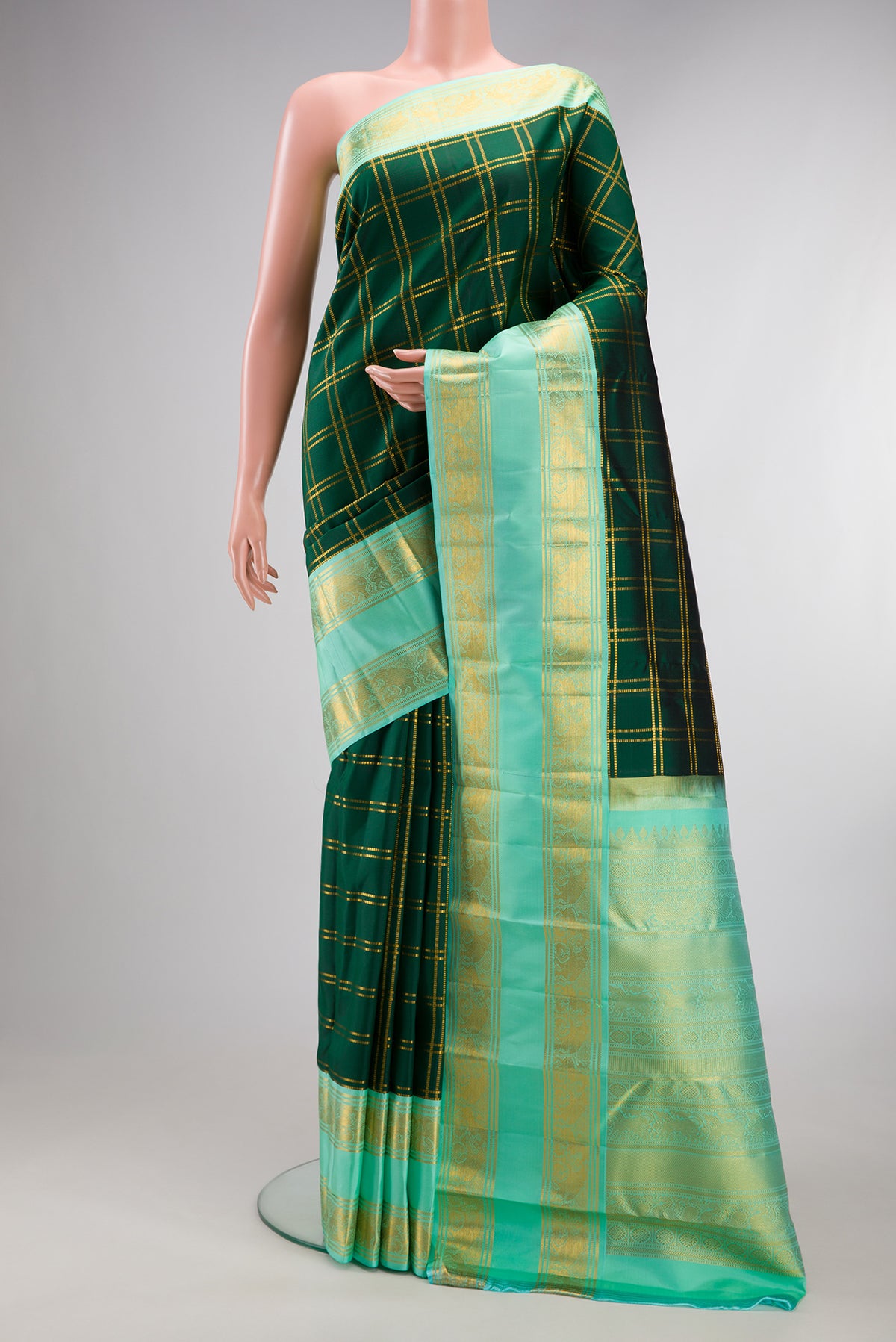 Pure Silk Bottle Green Kanjivaram Saree with Checked design on the body and Zari Border.  displayed on a mannequin
