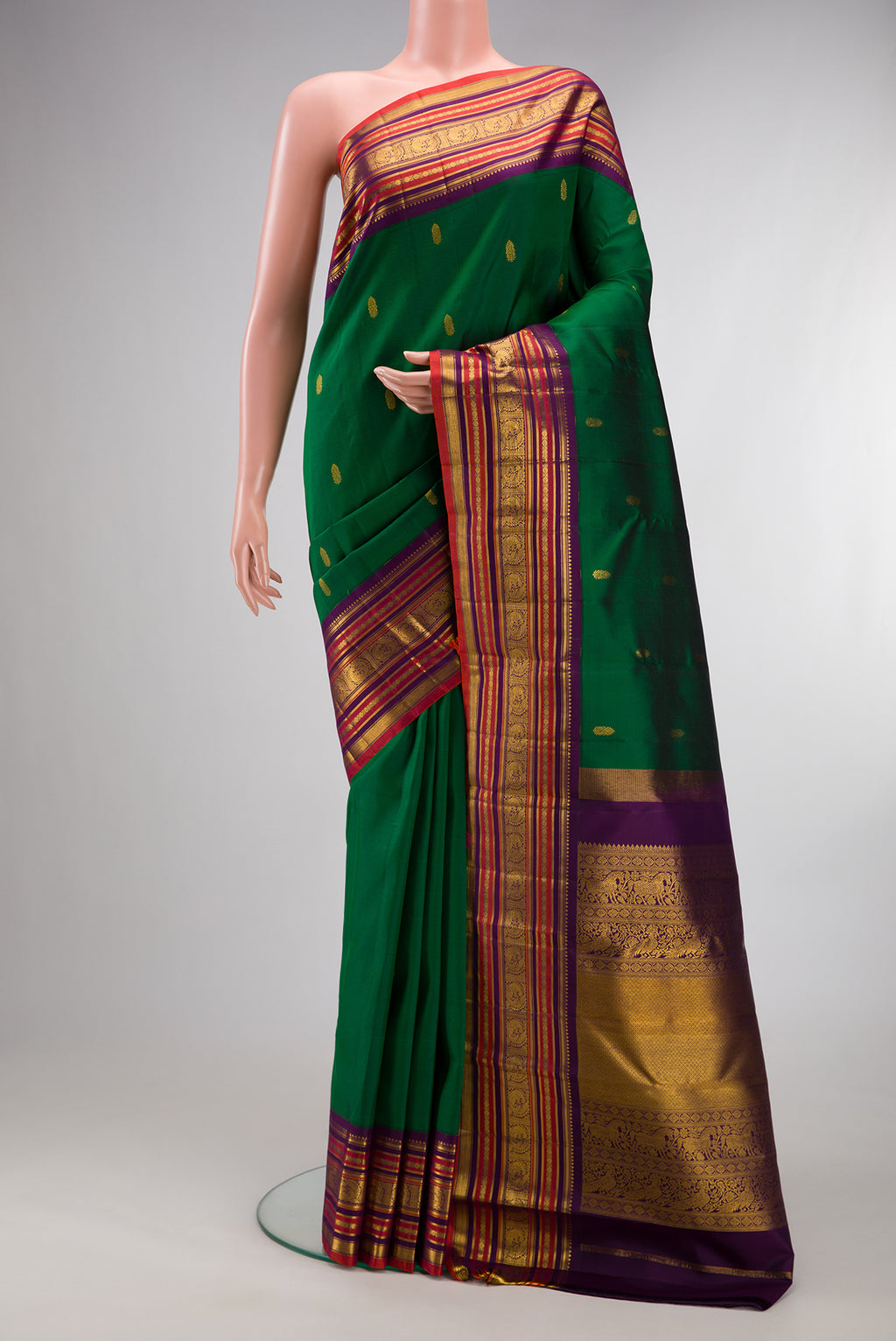 Pure Silk Bottle Green Kanjivaram Saree with Zari Butta on the body and Zari Border.  displayed on a mannequin