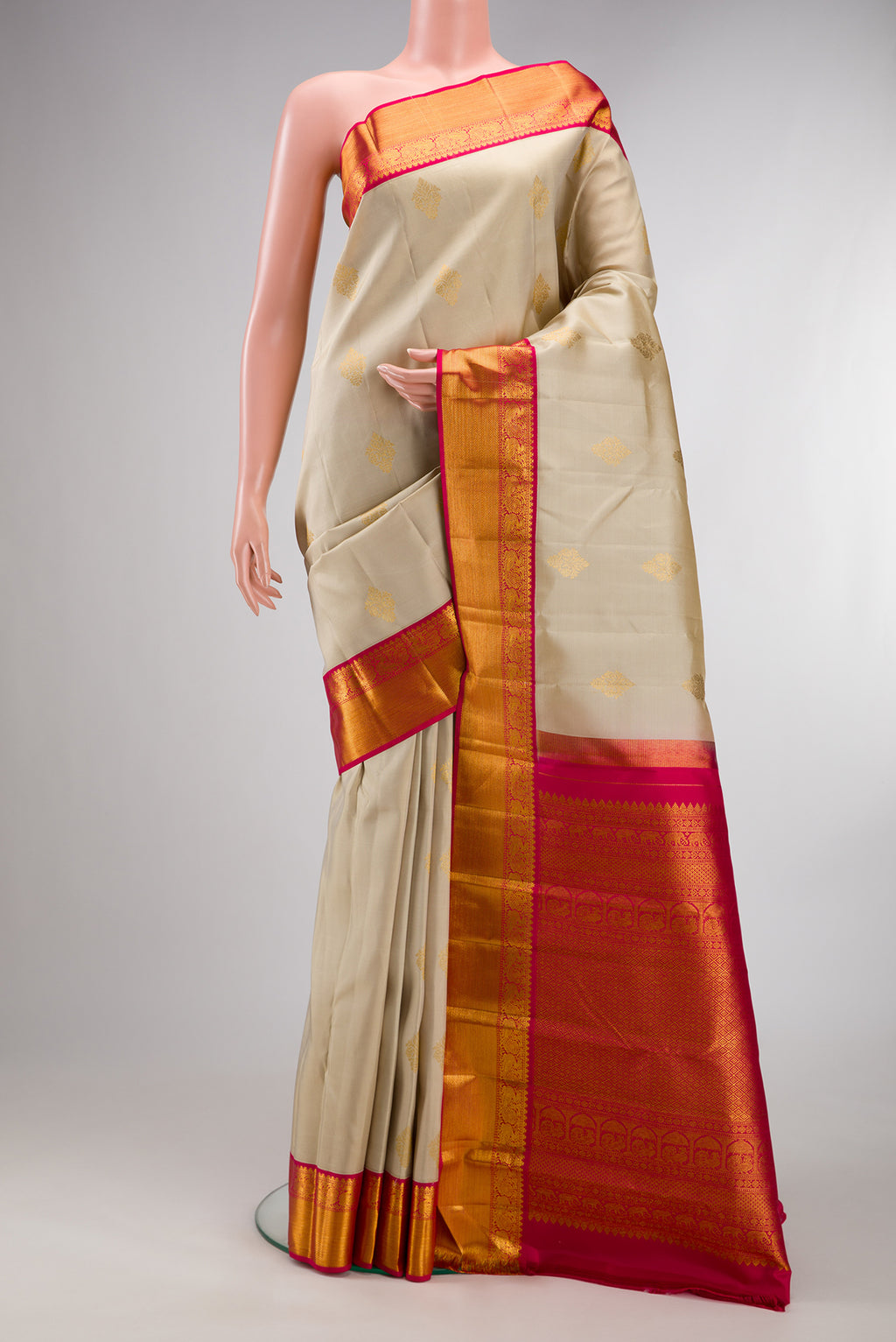 Pure Silk Beige Kanjivaram Saree with Zari Butta on the body and Zari Border.  displayed on a mannequin