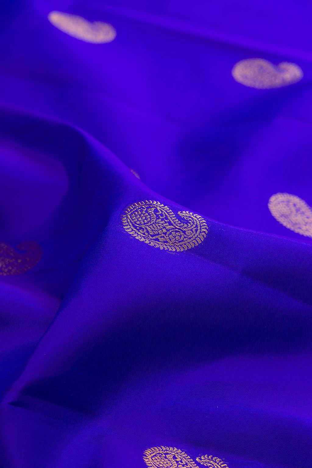 Close up of Pure Silk Royal Blue Kanjivaram Saree with Zari Butta on the body and Zari Border.  displaying folds