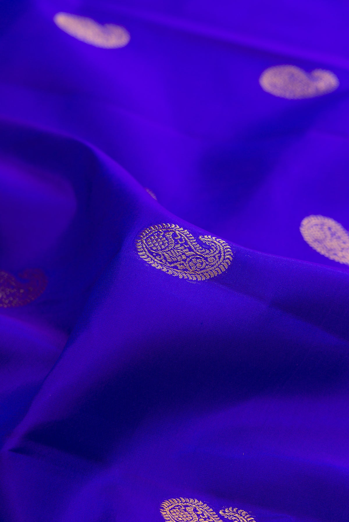 Close up of Pure Silk Royal Blue Kanjivaram Saree with Zari Butta on the body and Zari Border.  displaying folds