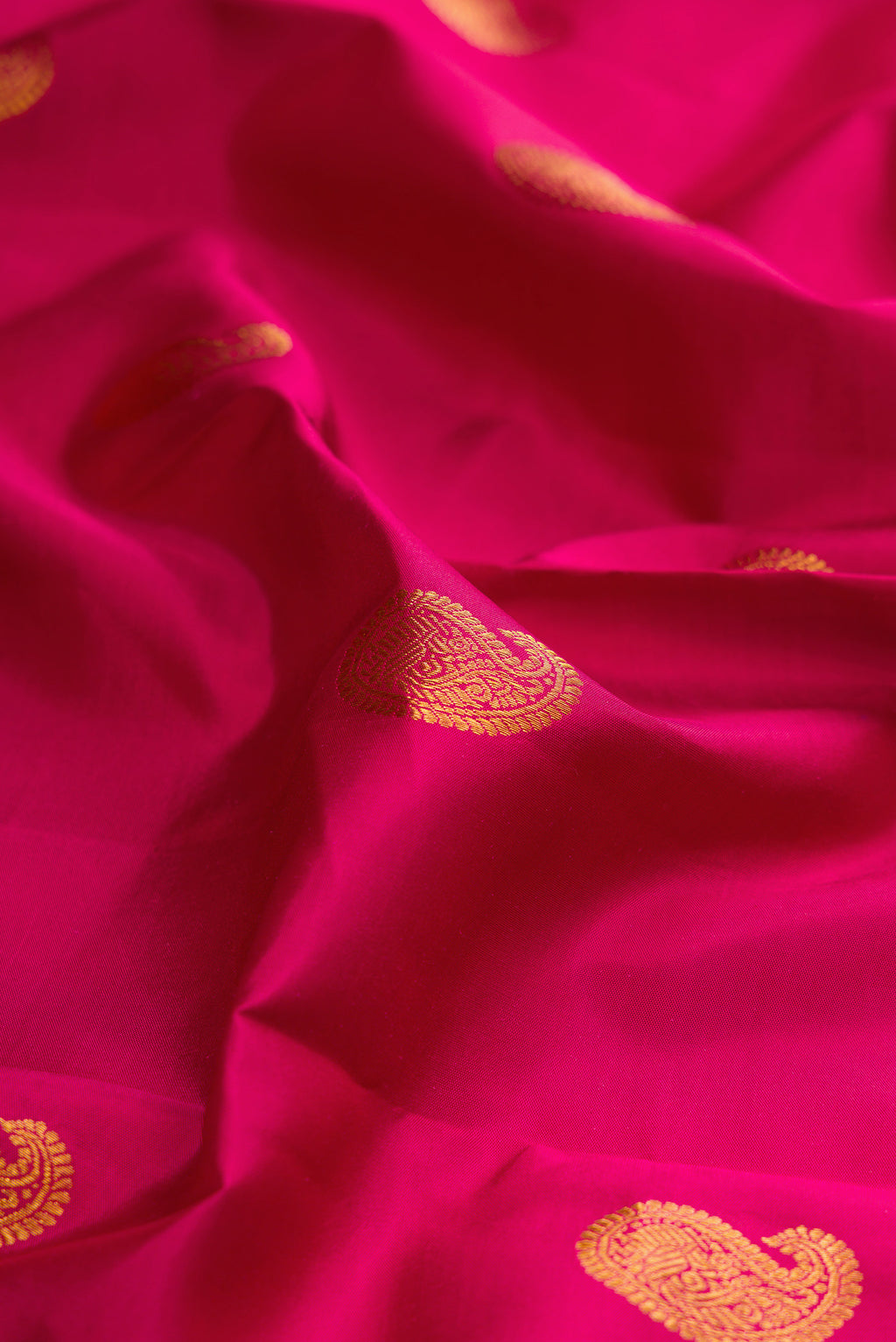 Close up of Pure Silk Magenta Kanjivaram Saree with Zari Butta on the body and Zari Border.  displaying folds