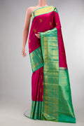Pure Silk Magenta Kanjivaram Saree with Zari Butta on the body and Zari Border.  displayed on a mannequin