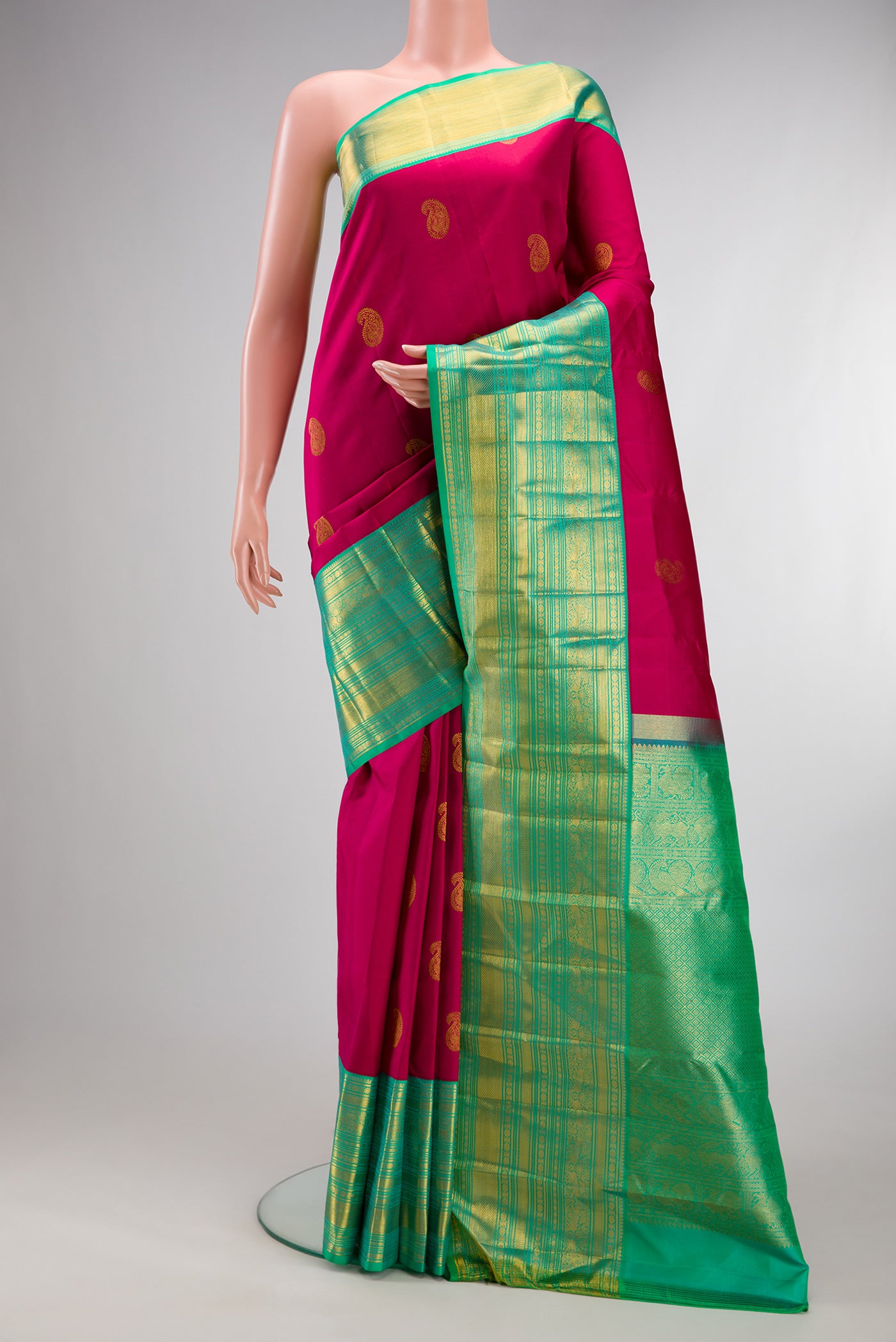 Pure Silk Magenta Kanjivaram Saree with Zari Butta on the body and Zari Border.  displayed on a mannequin