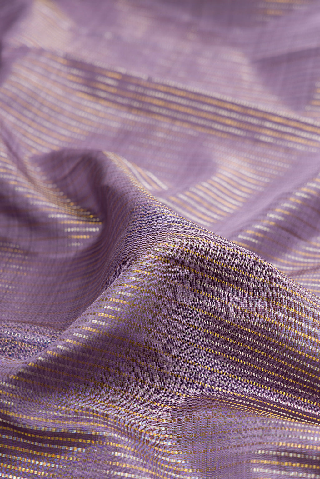 Close up of Pure Silk Lavender Kanjivaram Saree with Stripes on the body and Zari Border.  displaying folds