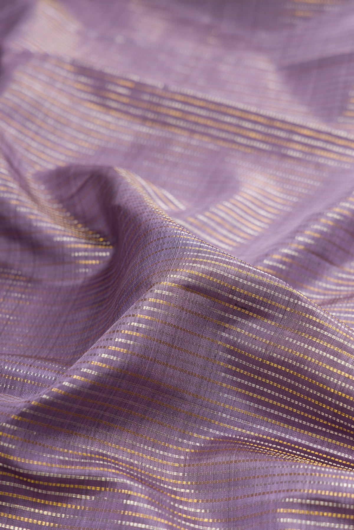 Close up of Pure Silk Lavender Kanjivaram Saree with Stripes on the body and Zari Border.  displaying folds