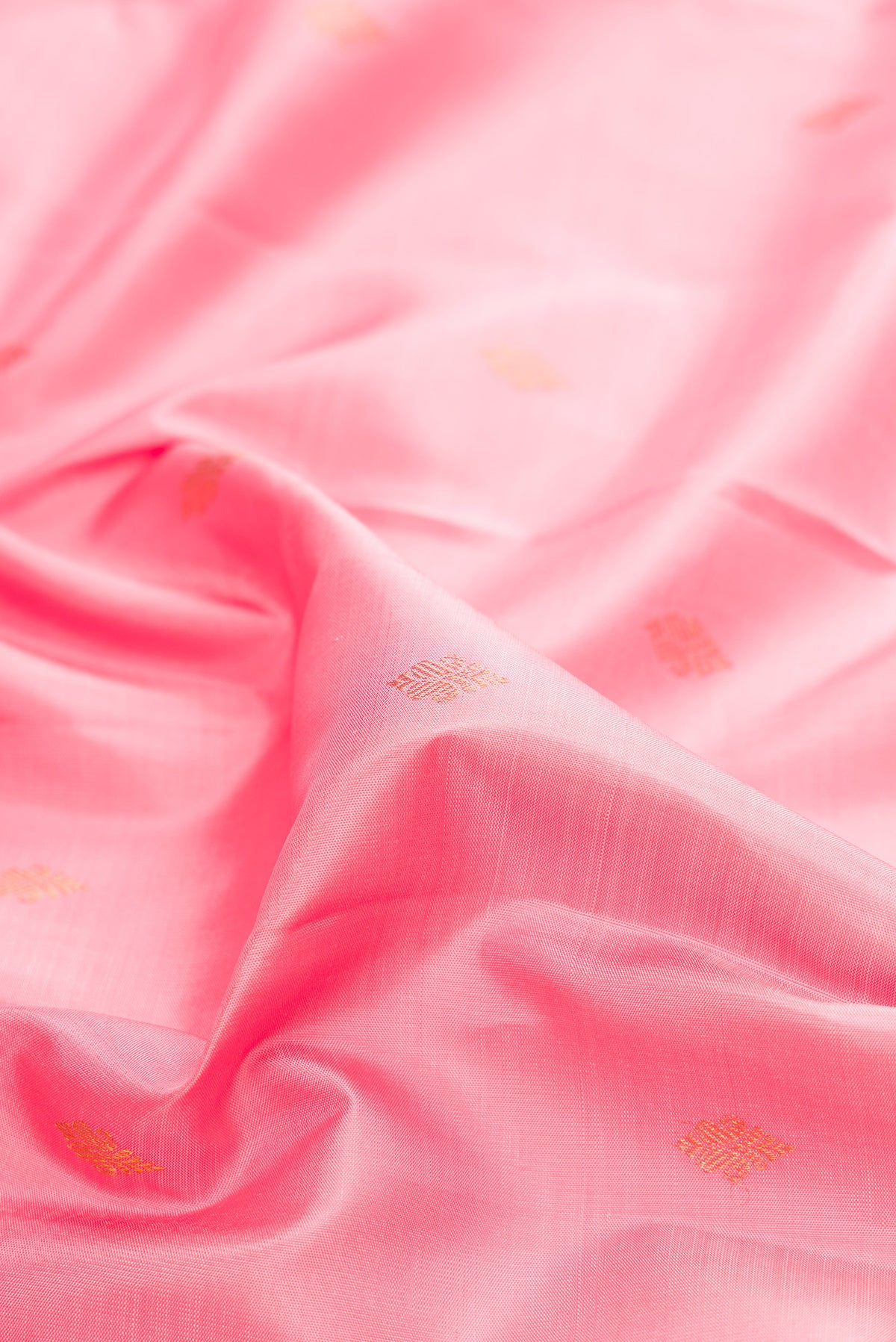 Close up of Pure Silk Rose pink Kanjivaram Saree with Zari Butta on the body and Zari Border.  displaying folds