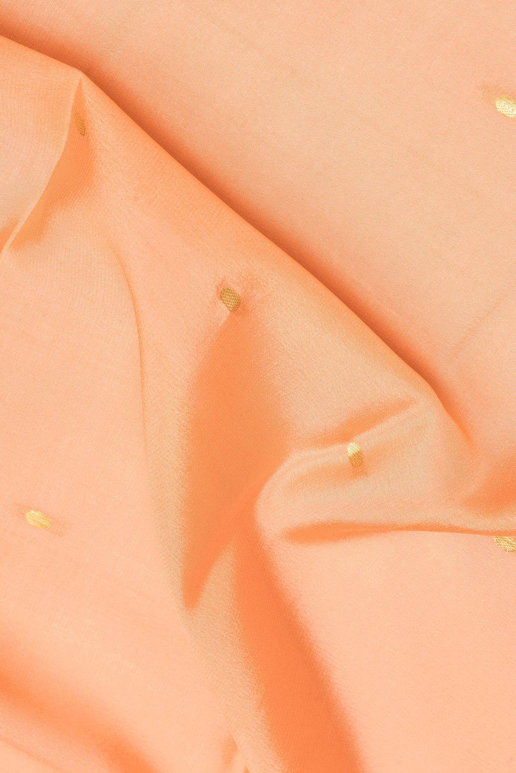 Close up of Peach Mysore Crepe Saree with Zari Butta on the body and Zari Border.  displaying folds
