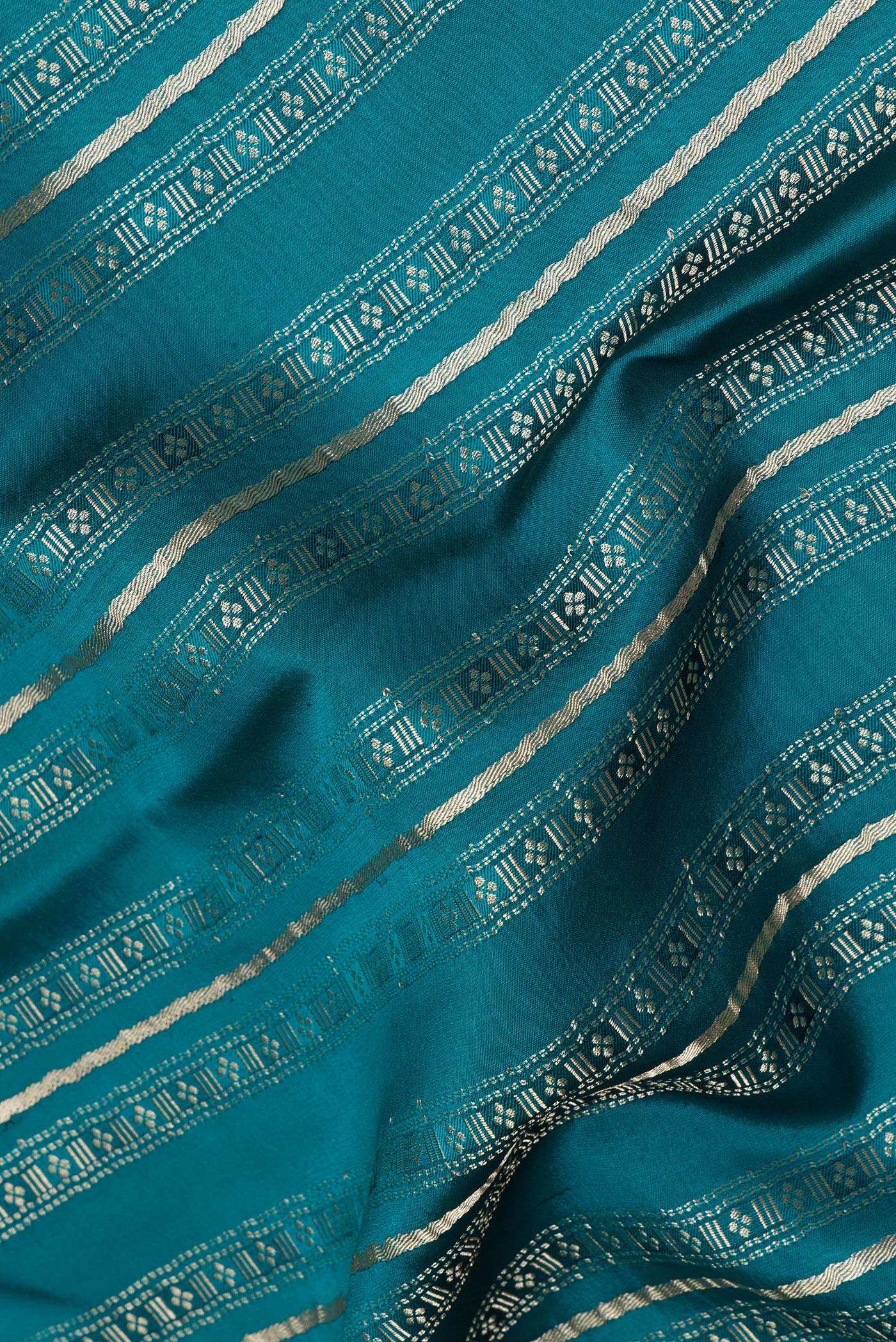 Close up of Peacock Blue Dual Tone Banarasi Georgette Saree with Zari Brocade on the body and Plain Border.  displaying folds