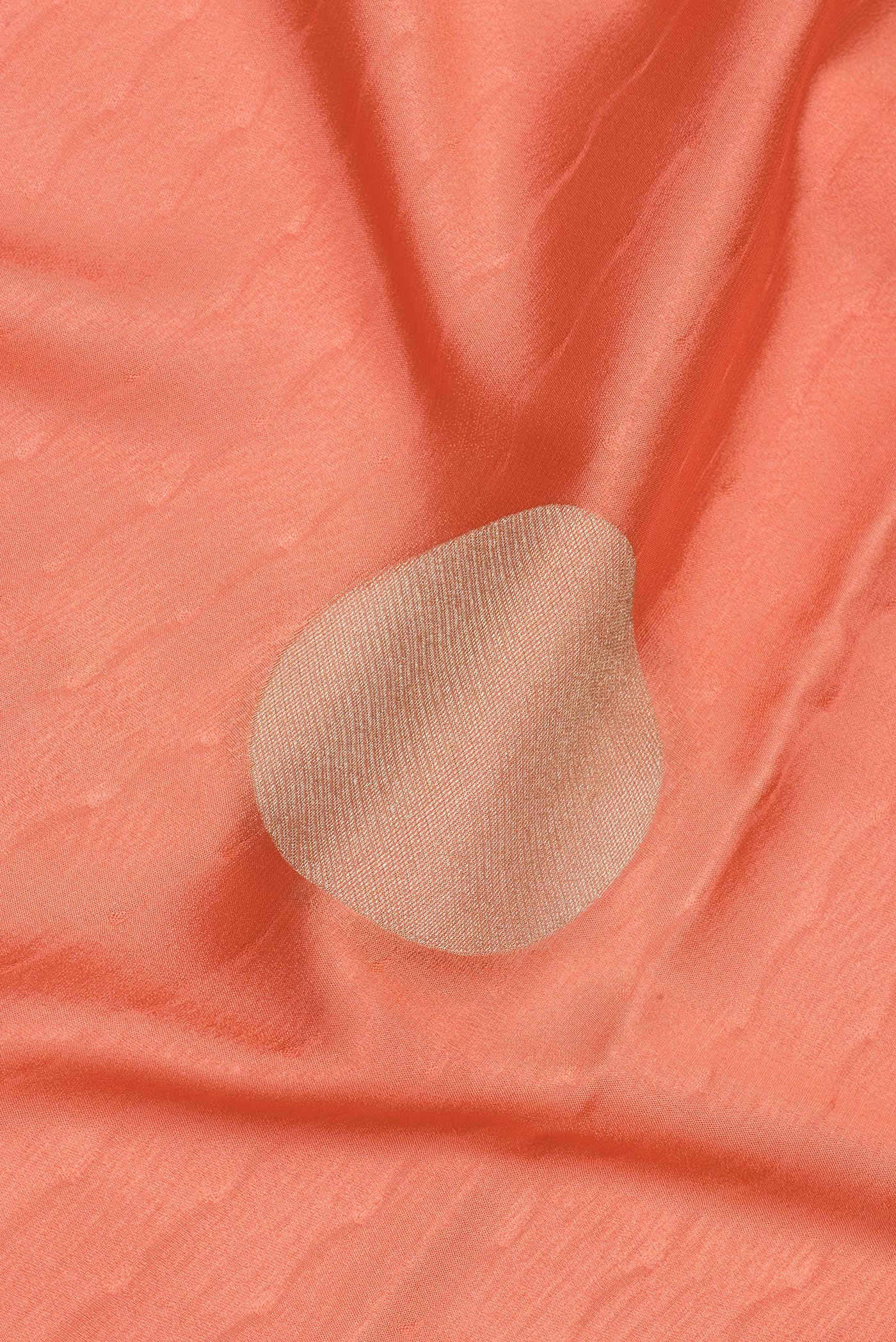 Close up of Peach Mysore Crepe Saree with Zari Butta on the body and Zari Border.  displaying folds