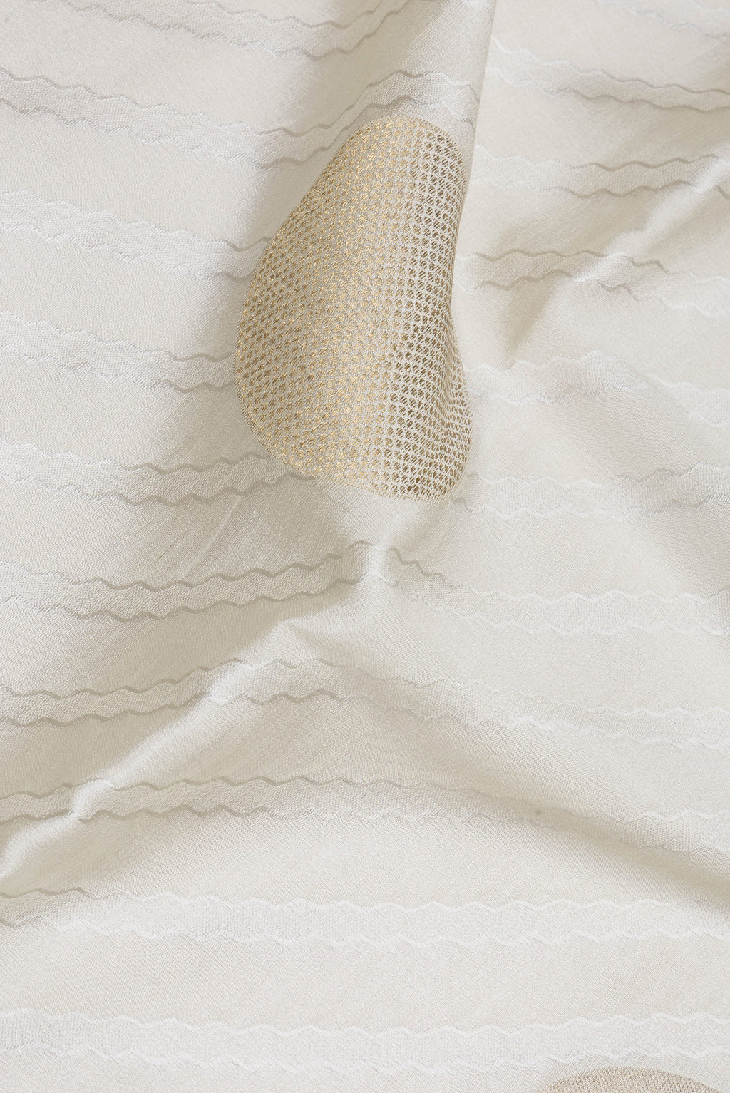 Close up of Beige Mysore Chiffon Saree with Zari Butta on the body and Zari Border.  displaying folds