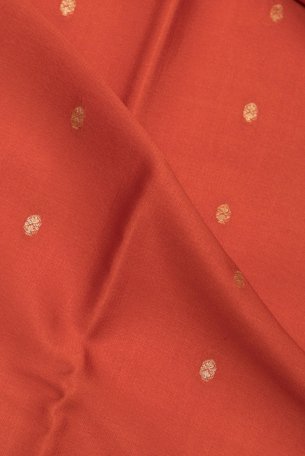 Close up of Brick Orange Dual Tone Georgette Saree with Zari Butta on the body and Zari Border.  displaying folds