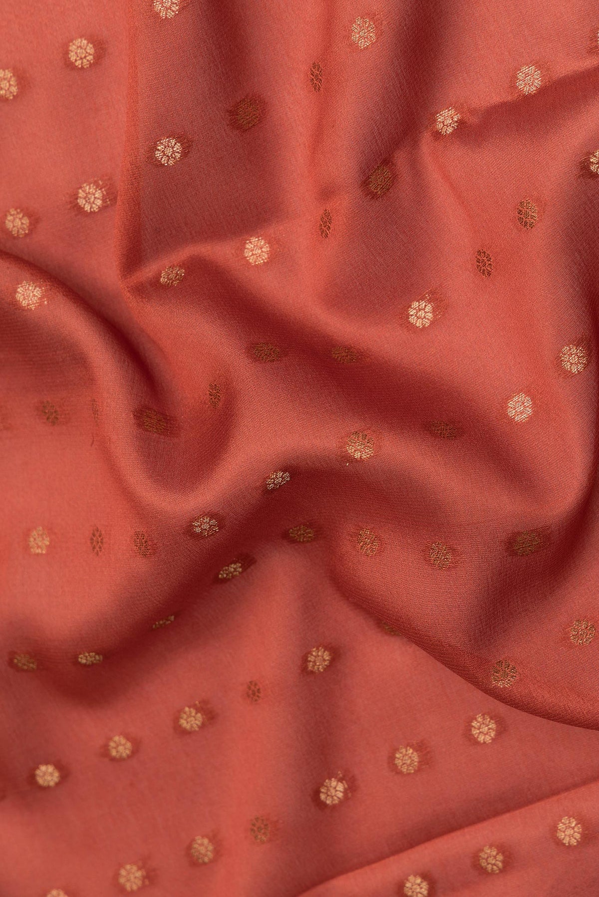 Close up of Rust Dual Tone Georgette Saree with Zari Butta on the body and Zari Border.  displaying folds